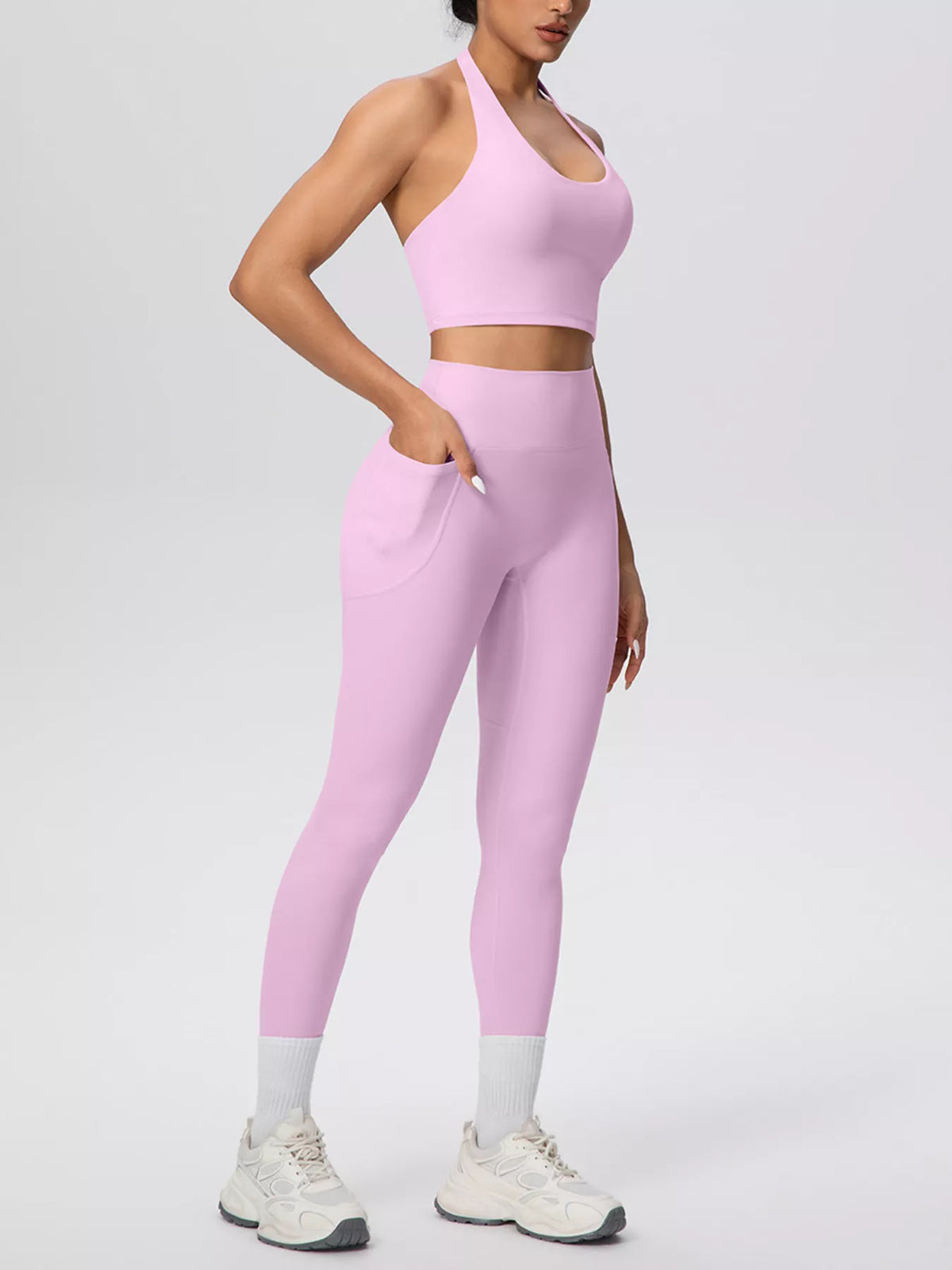 Blush pink halter crop top and high-waist pocketed leggings, side view, full-length