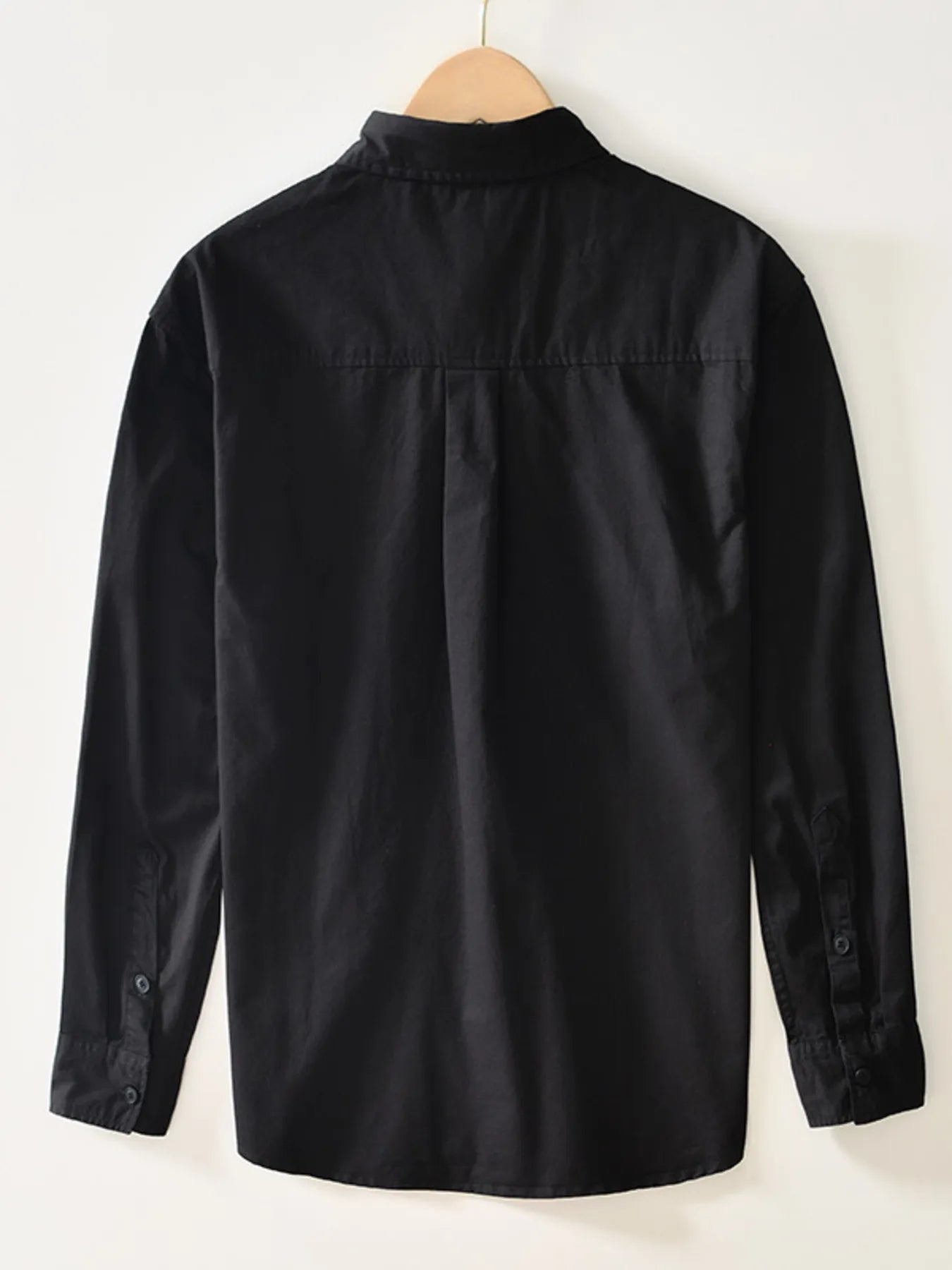 Black button-up long sleeve shirt, back view with yoke and curved hem