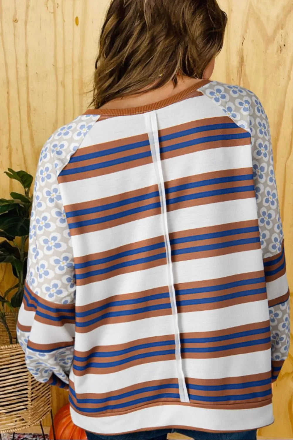 Back view raglan sweatshirt: white with blue and orange stripes, floral raglan sleeves, center seam