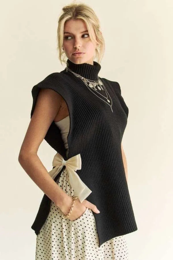 Black sleeveless knit turtleneck top with ribbed texture and side tie detail