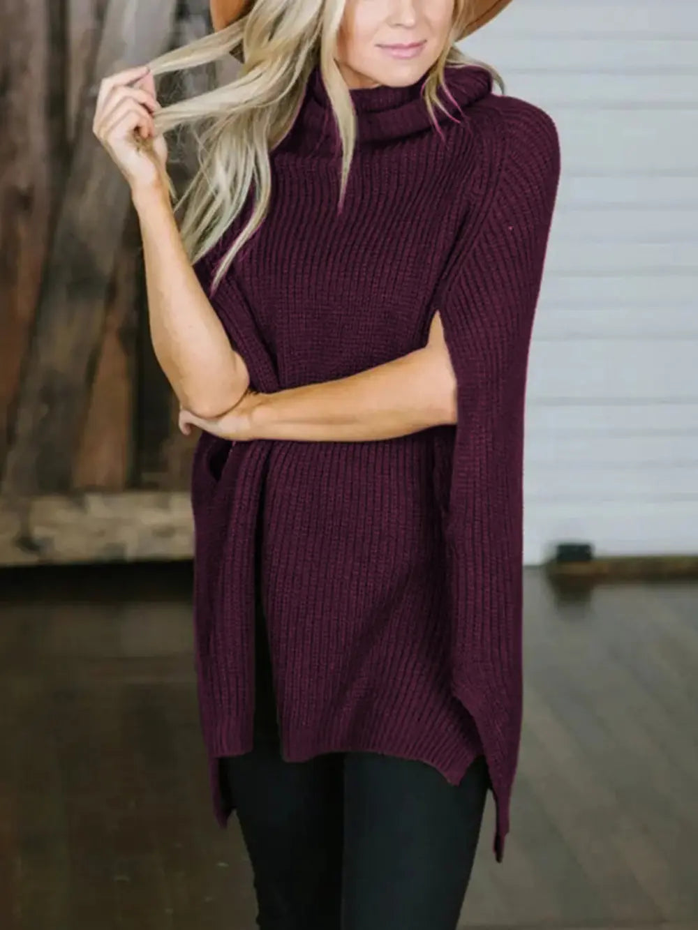 Burgundy turtleneck slit sweater with ribbed knit collar and asymmetrical side hem.