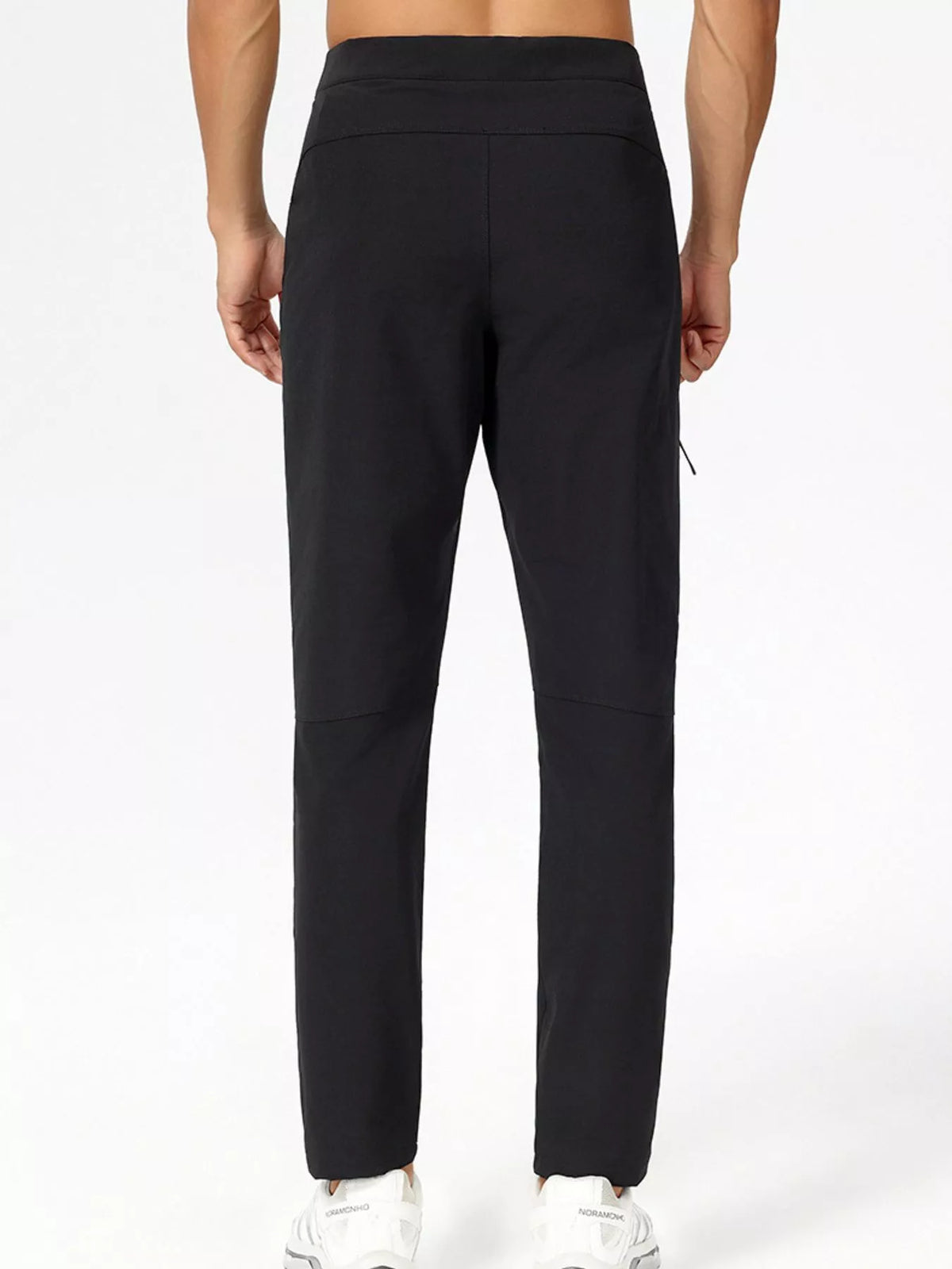 Men's slim-fit stretch casual pants in black, front view with tapered legs and pockets