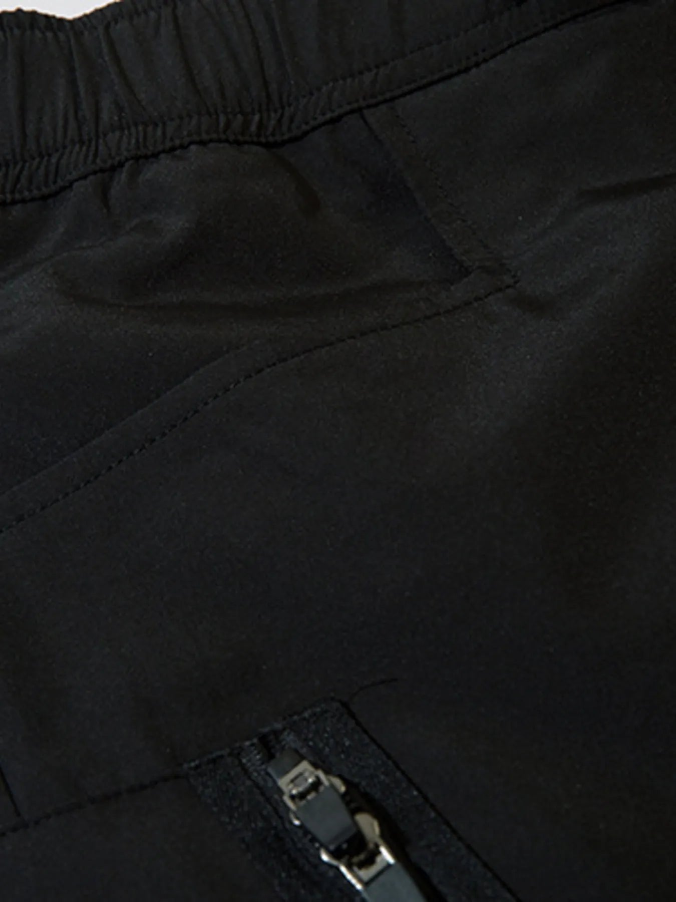 Black cargo joggers showing a zip pull on the side pocket panel