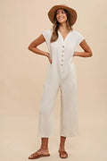 Cream button-front wide-leg jumpsuit with short sleeves and side pockets