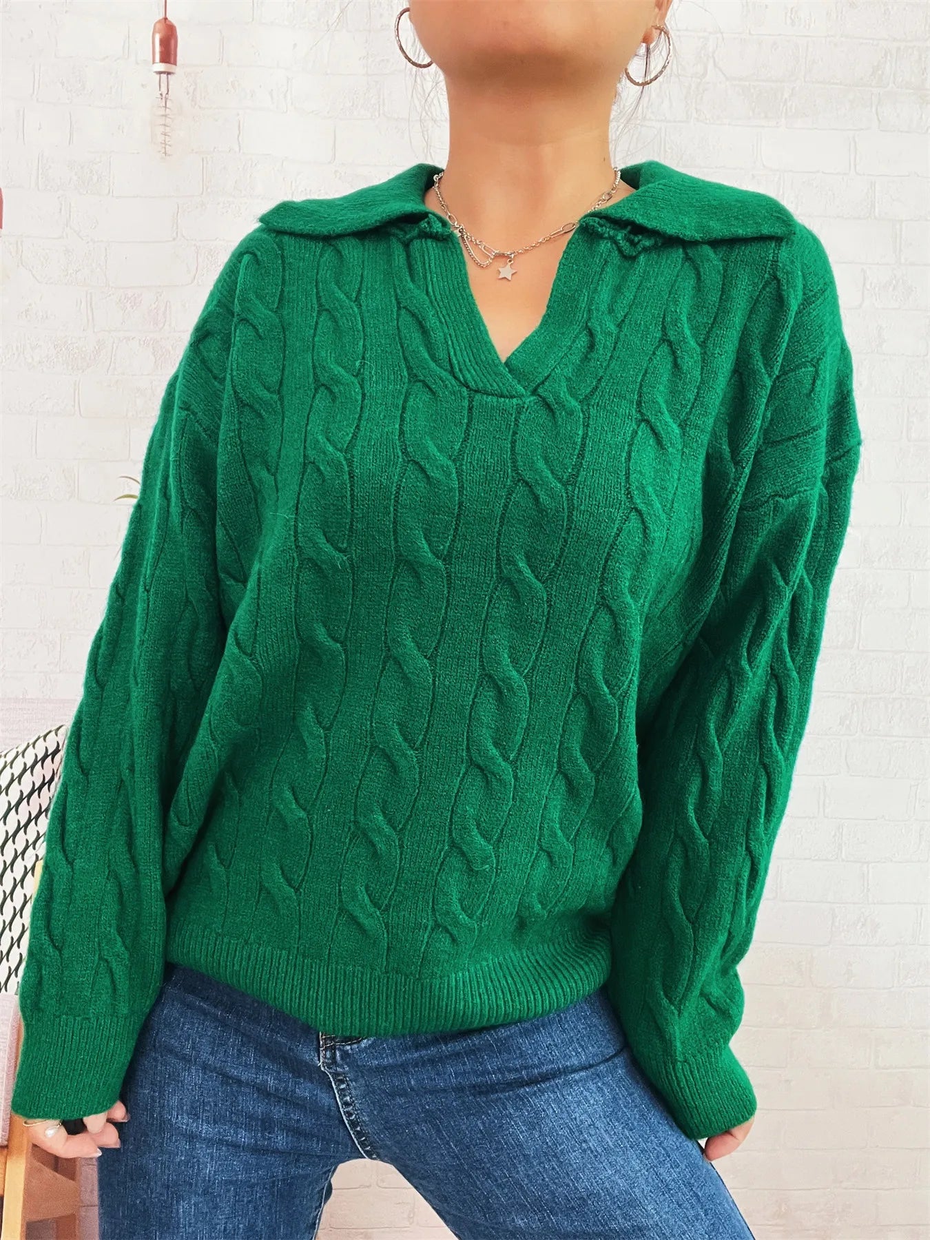 Green cable-knit johnny-collar sweater with long sleeves, cable texture and V neckline.