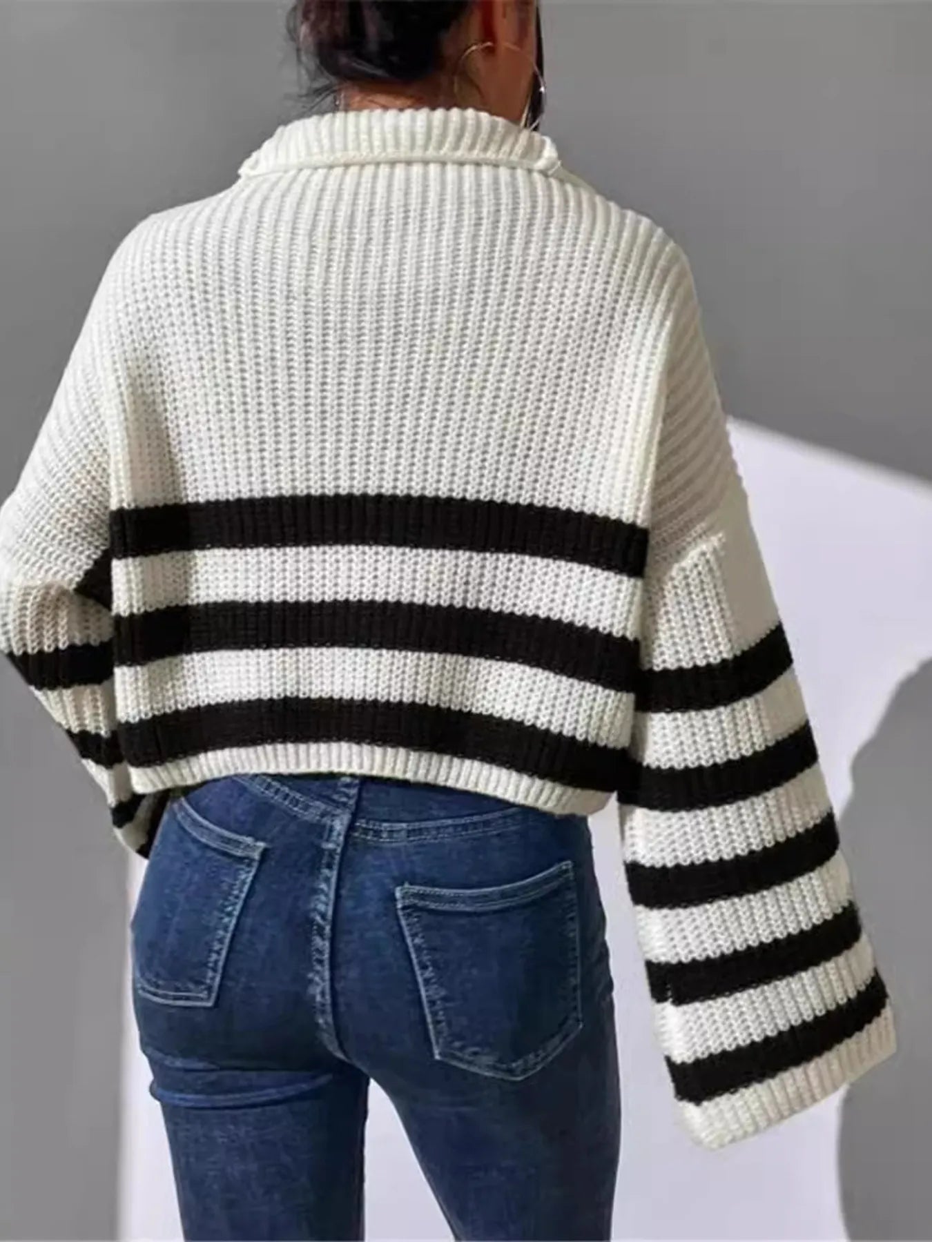Back view of white ribbed cropped sweater with black-and-white striped banding