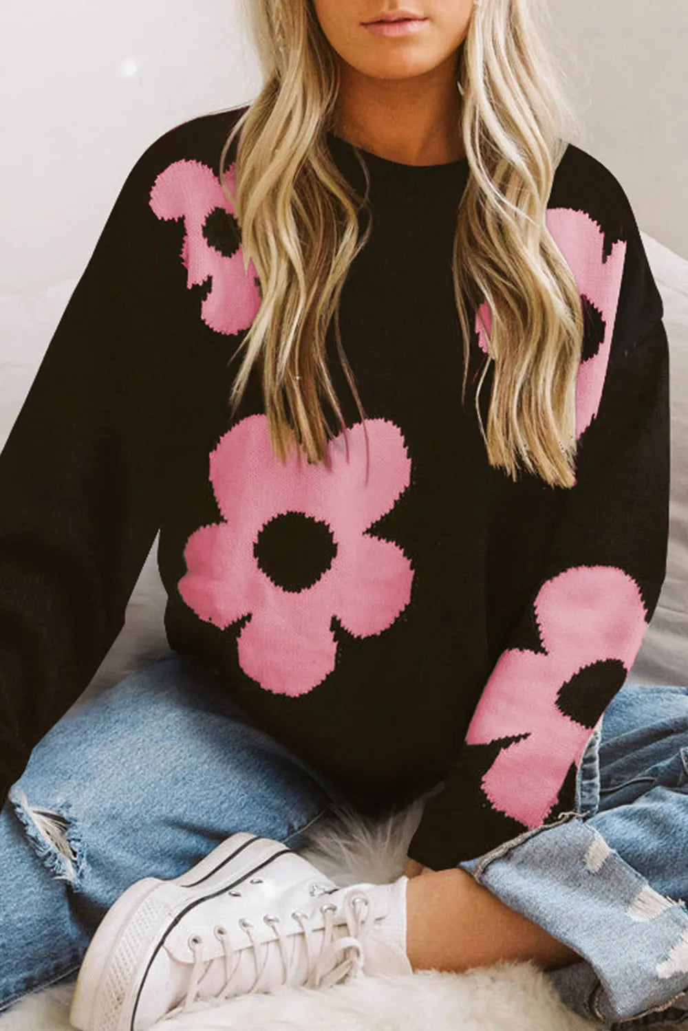 Black long-sleeve sweater with pink floral intarsia pattern on the front