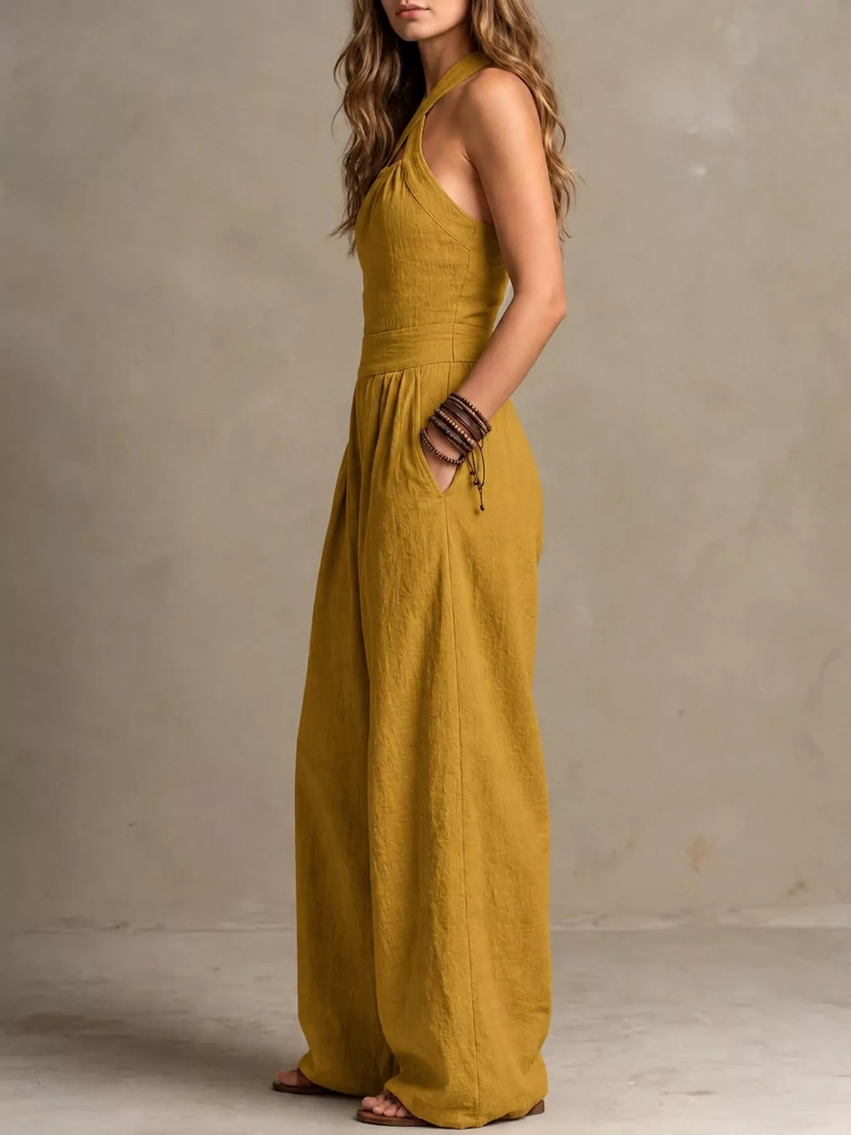 Yellow linen halter jumpsuit with gathered high waist and wide pant legs