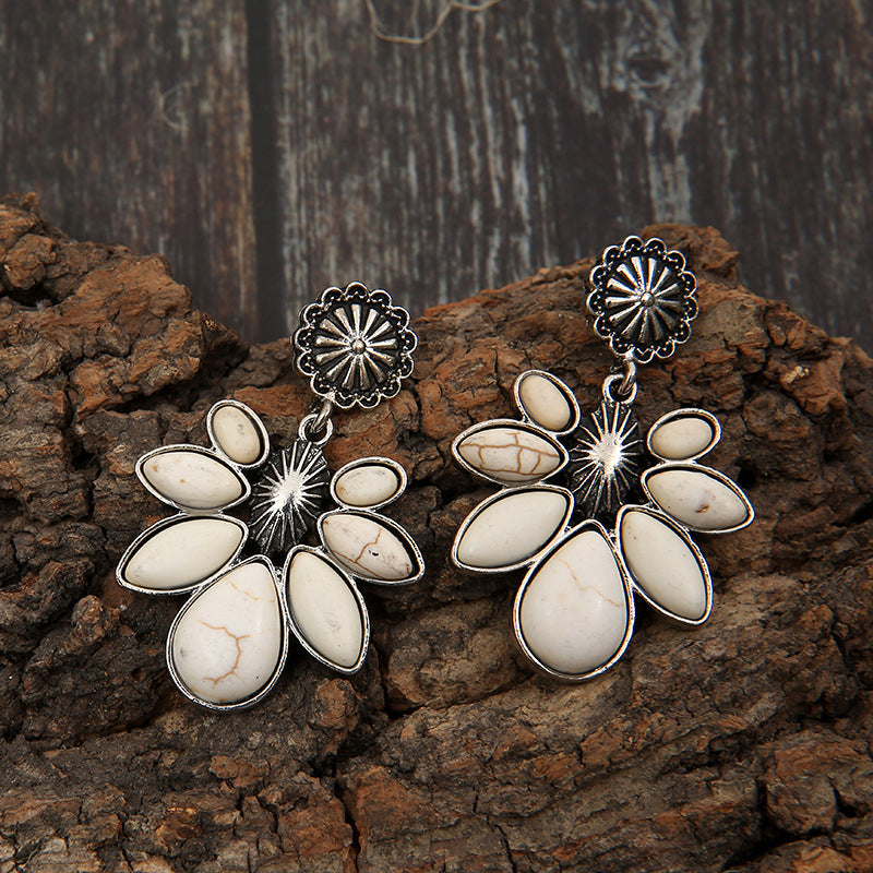 Silver-tone flower earrings with dangling teardrop petals and central sunburst detail
