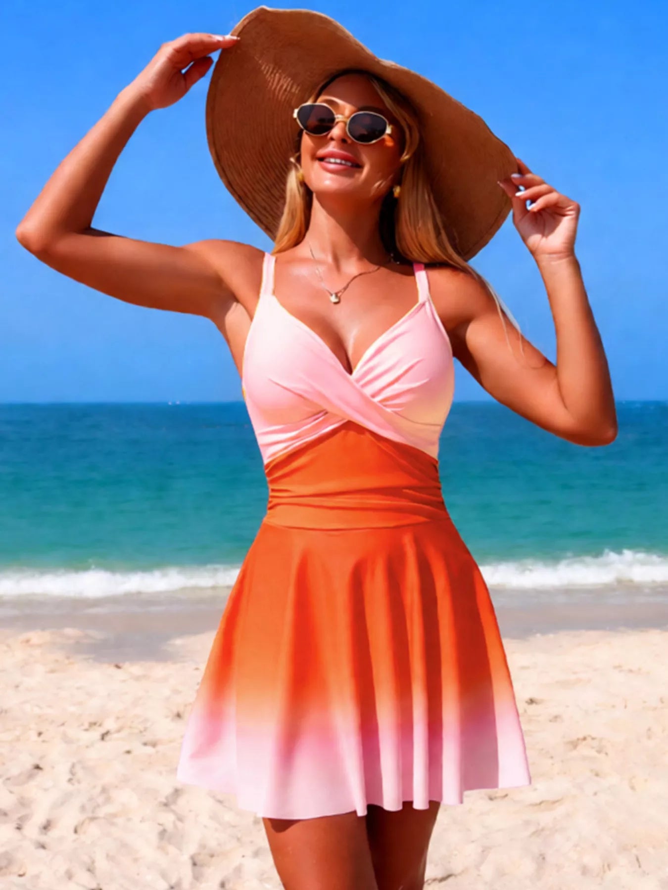 V-neck gradient one-piece swimsuit in pink to orange ombre on a model at the beach