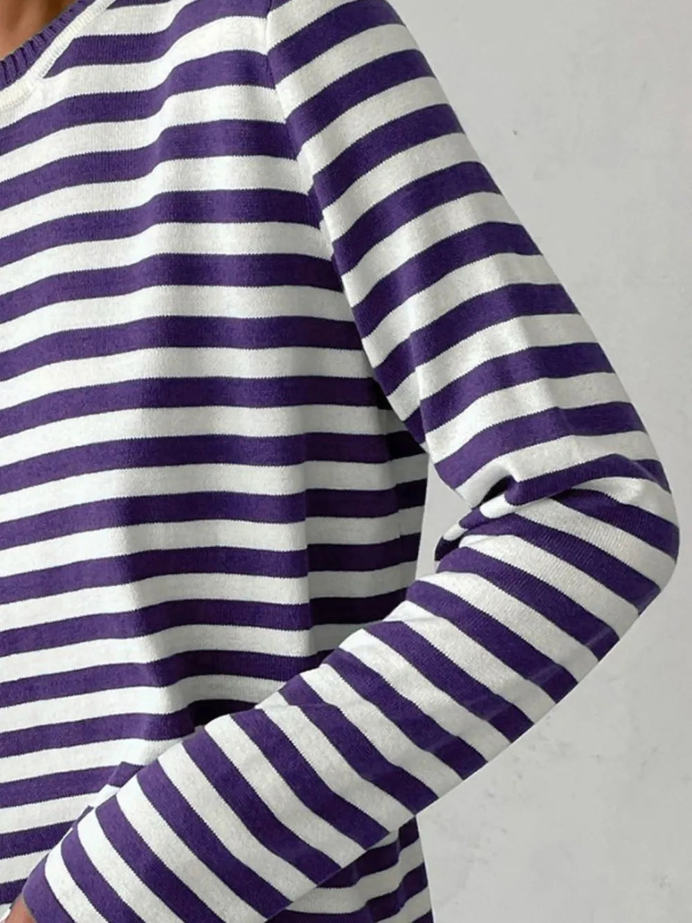 Striped long-sleeve sweater sleeve detail with purple and white stripes