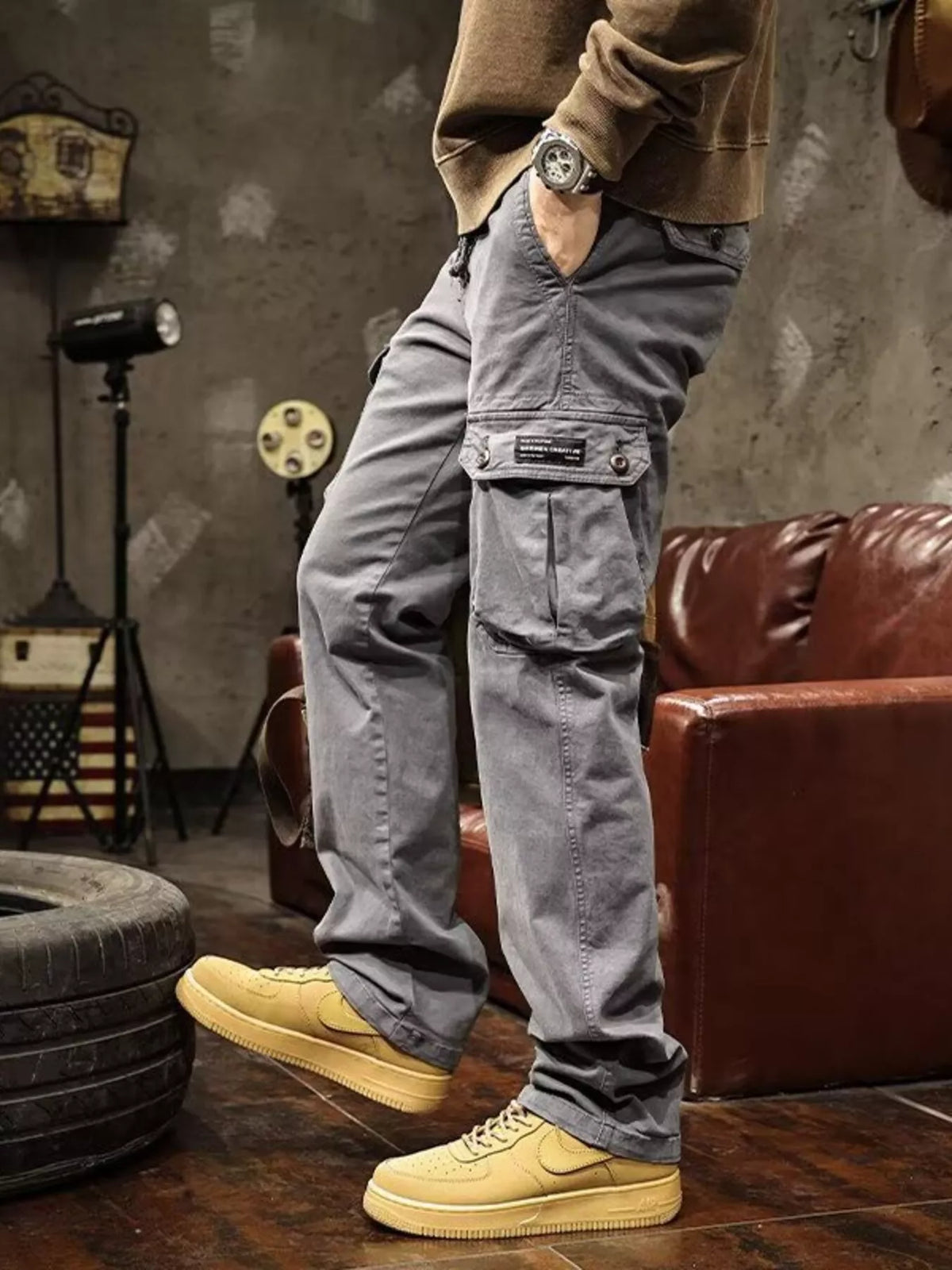 Mens multi-pocket drawstring cargo pants in light gray with front flap pockets