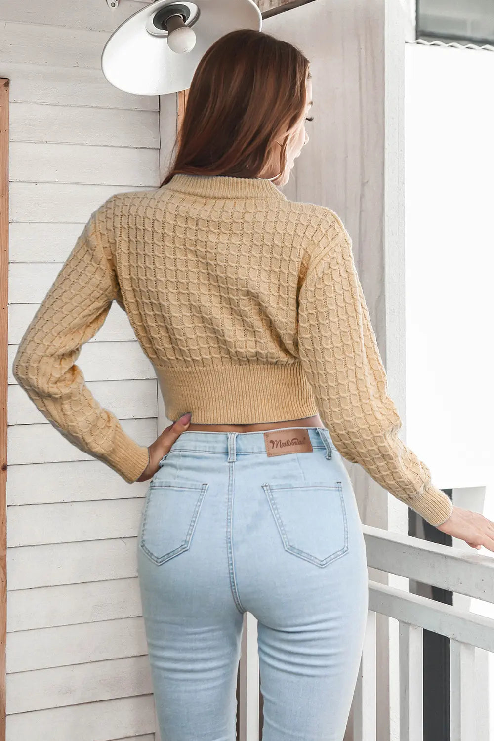 Camel cropped knit sweater with round neck and long sleeves, textured back view.