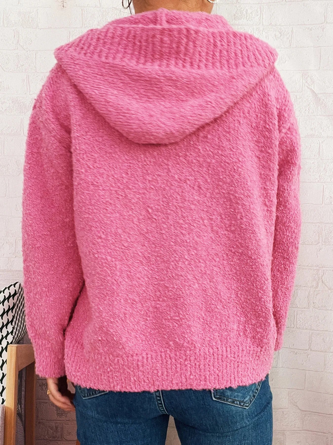 Back view of pink hooded cardigan with fuzzy knit and ribbed cuffs, long sleeves.