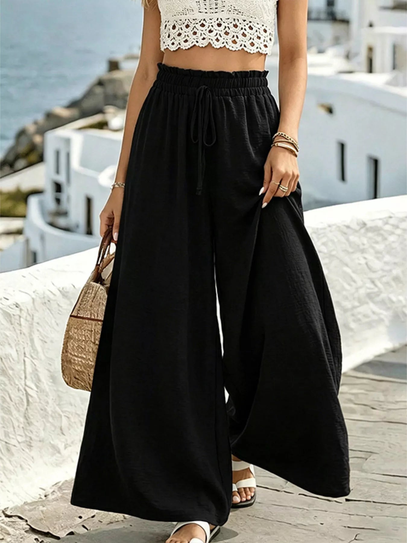 Black wide-leg drawstring pants with elastic waistband, tie drawstring, and flowing wide legs