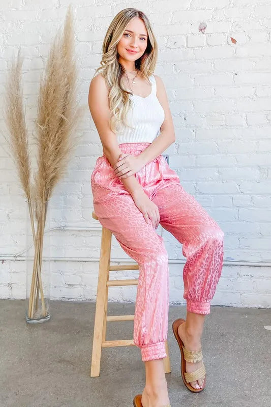 Pink satin leopard print joggers with elastic waist and cuffed ankle hem
