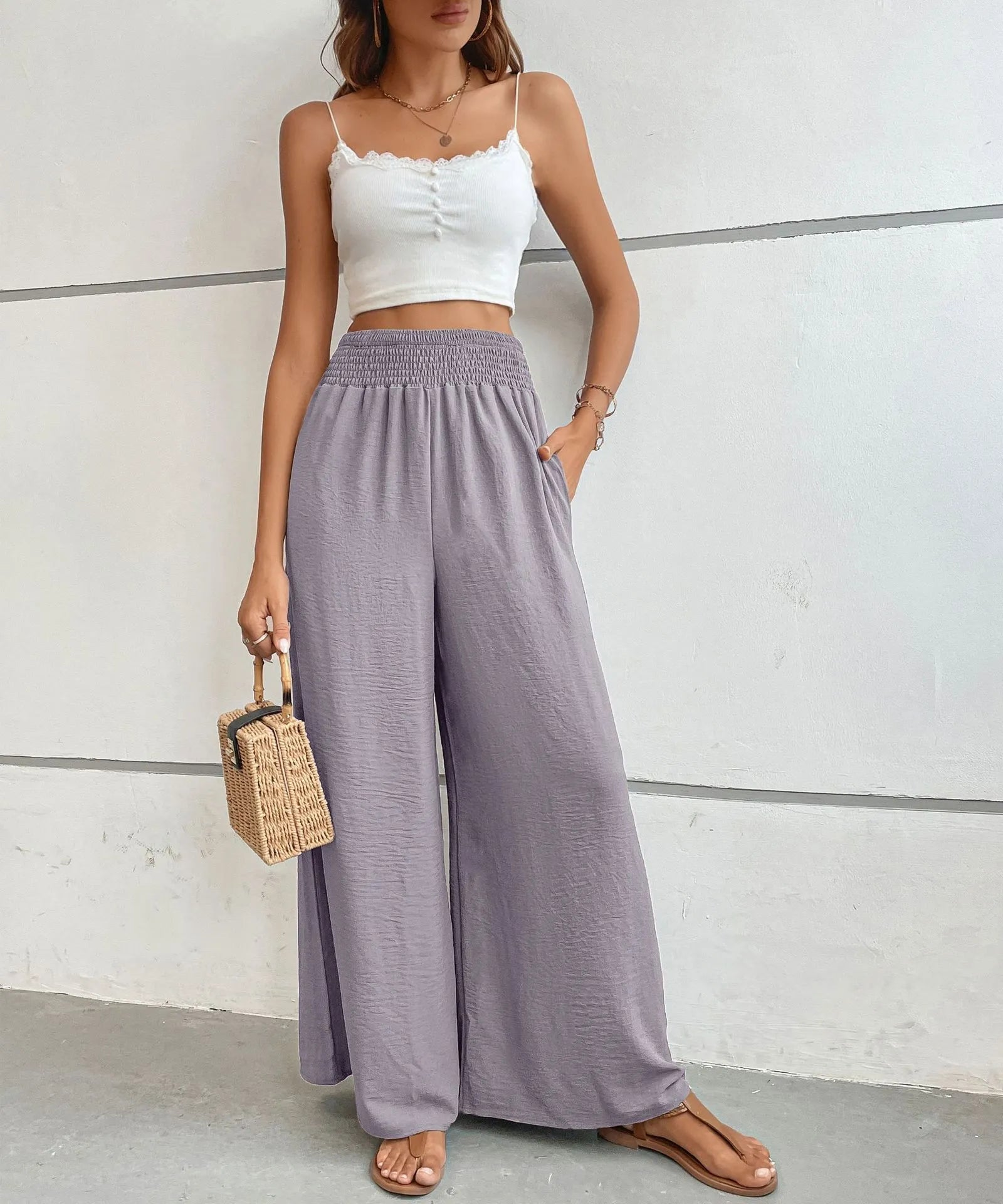 High-waisted wide-leg pants in lilac with elastic smocked waist and flowing wide-leg legs.