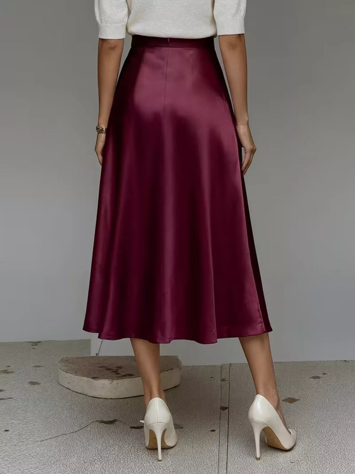 High-waist satin midi skirt in wine red, pleat-free A-line shape with glossy finish.