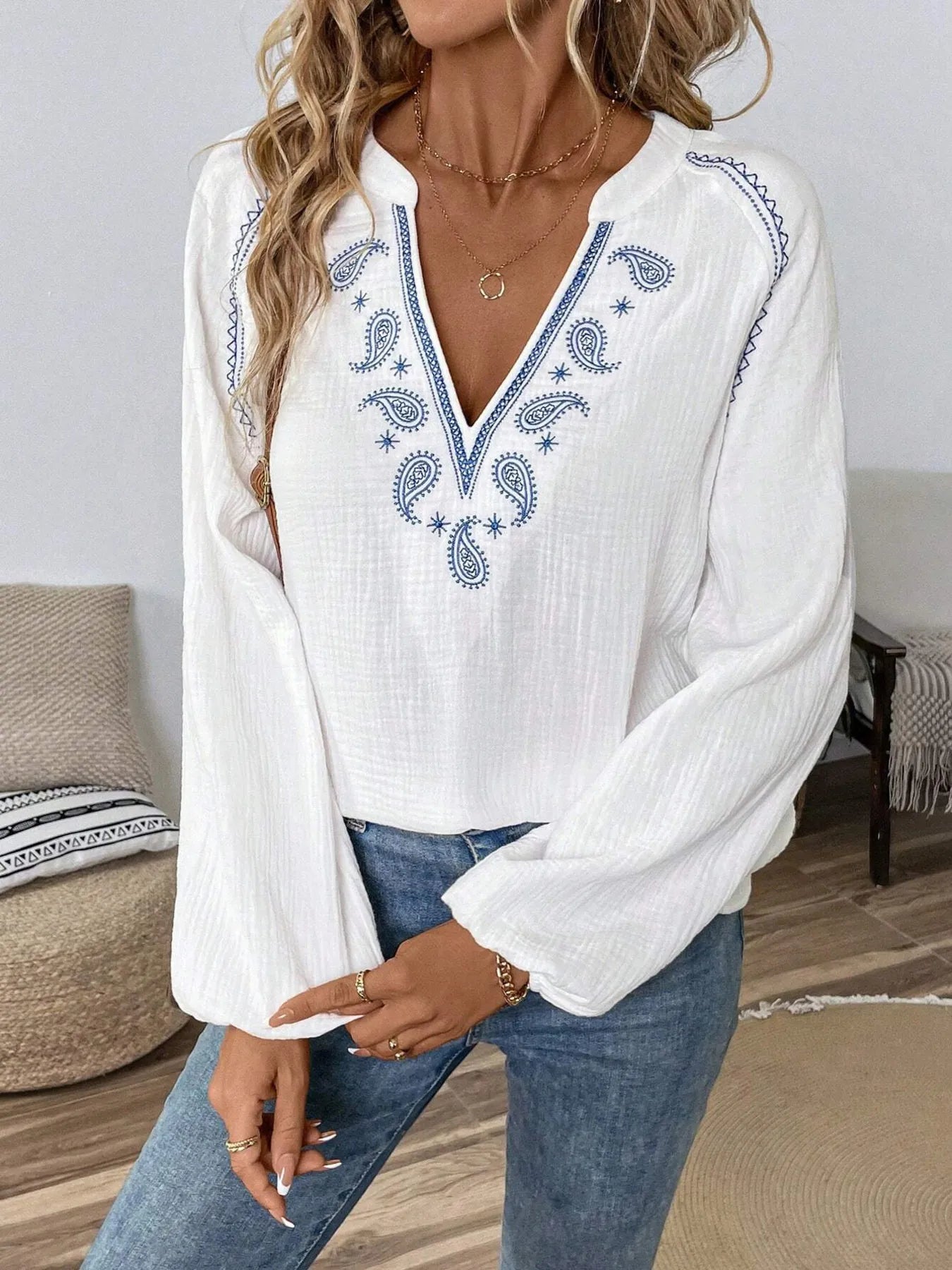 Long-sleeve blouse in white with blue paisley trim along V-neck and sleeves