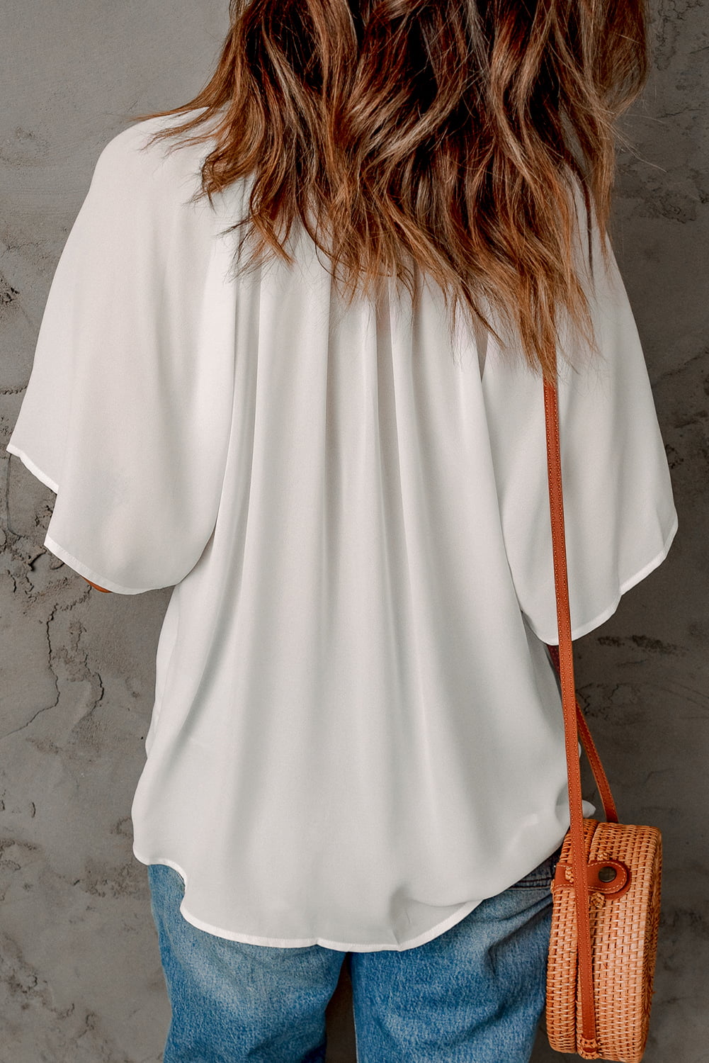 White gathered-back flutter sleeve top with flowy hem and loose drape