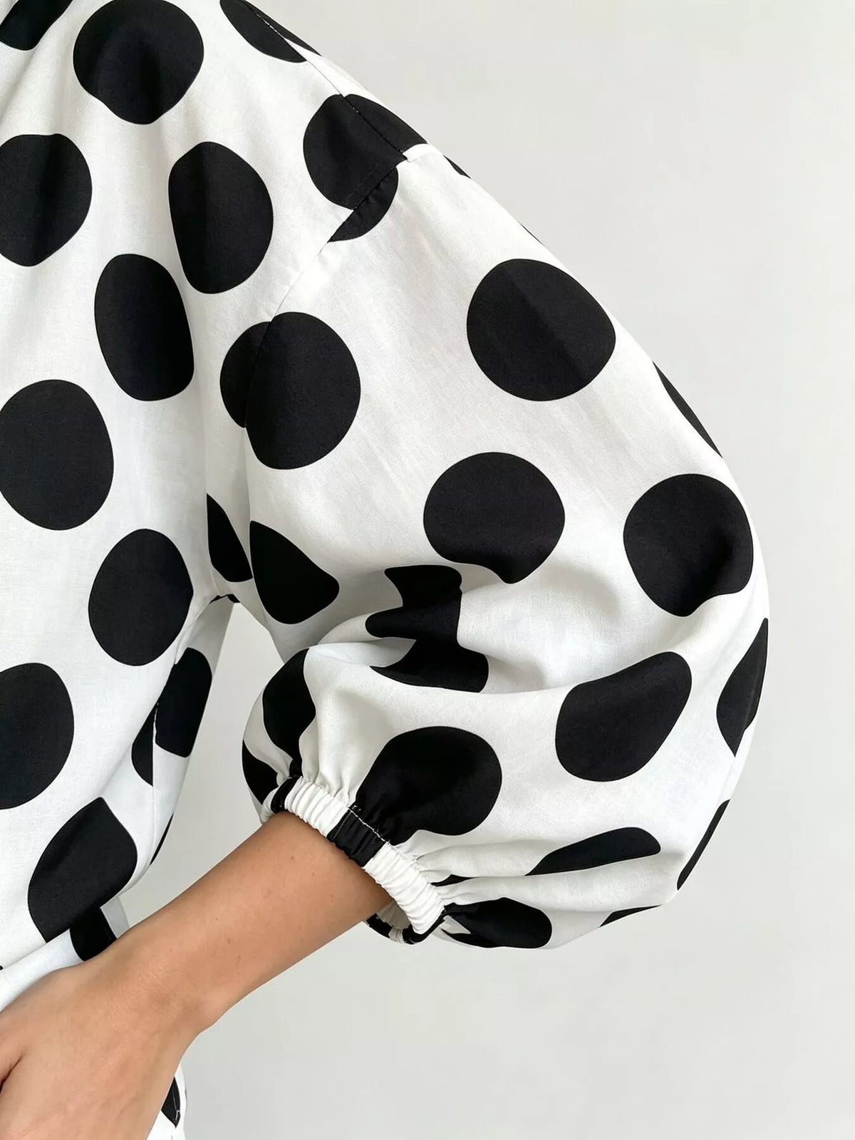 White polka dot puff sleeve shirt with elastic cuff detail