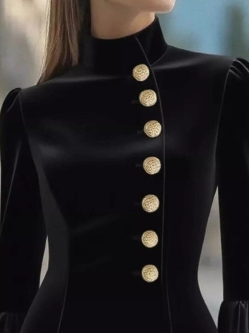 Black mini dress close-up with stand collar and gold front buttons.