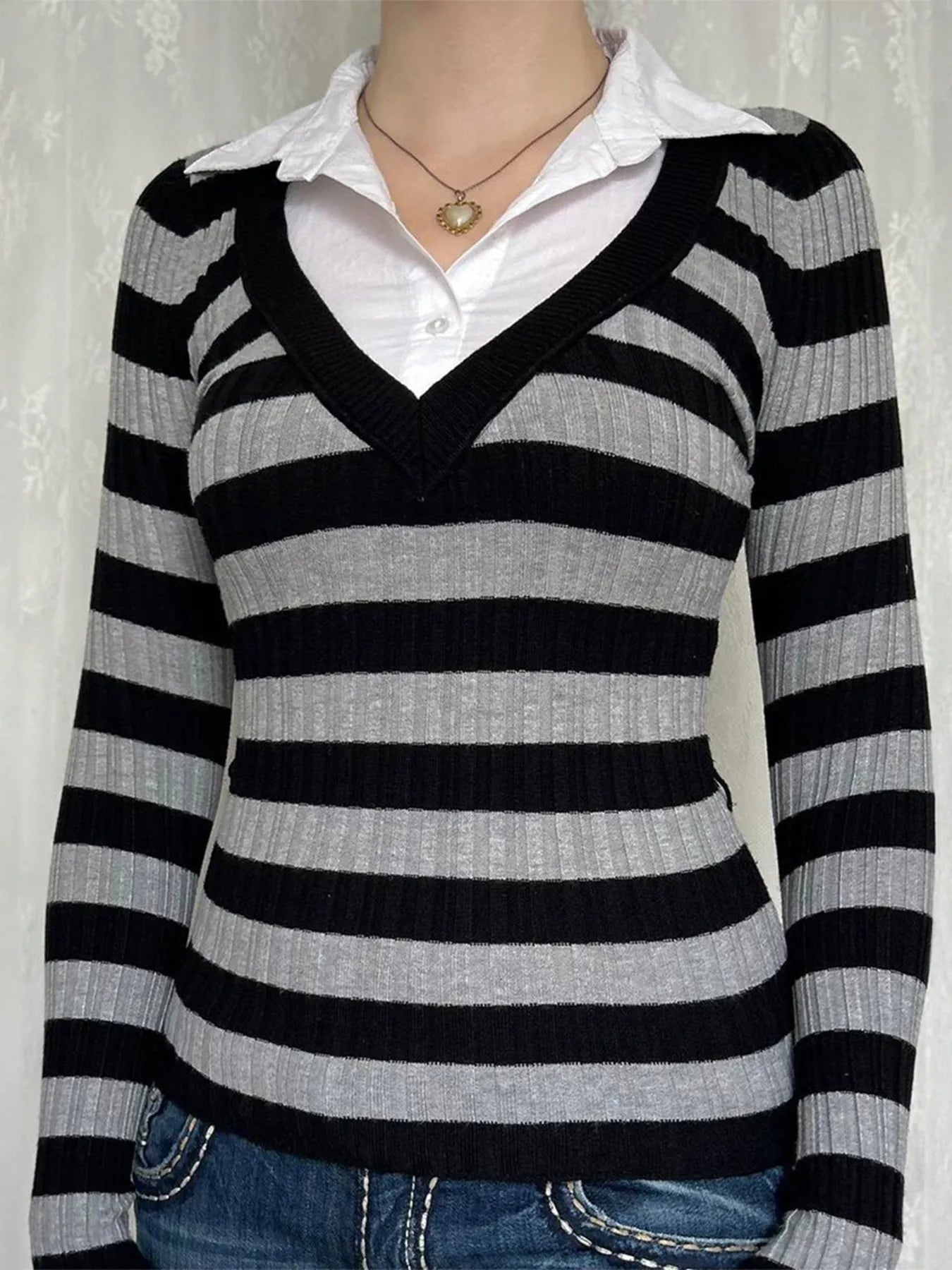 Striped knit long-sleeve top with black V-neck trim and white button-up shirt collar