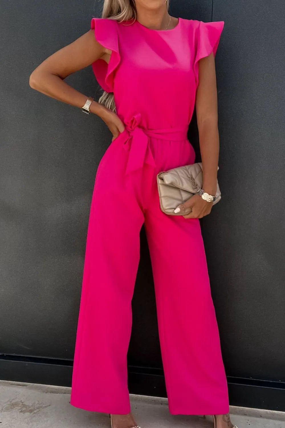 Hot pink round-neck cap sleeve jumpsuit with ruffled shoulders and tied waist