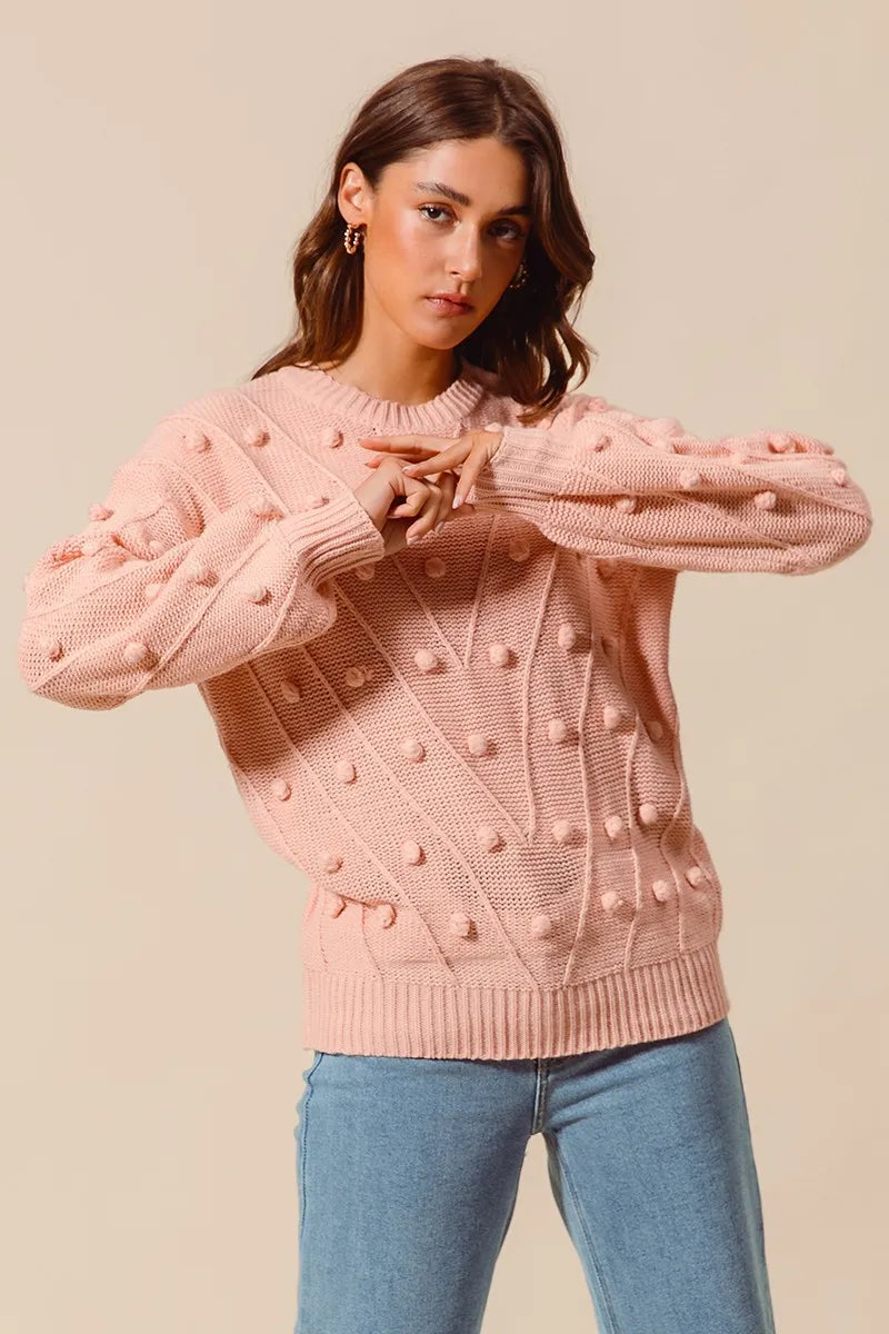 Blush pom-pom knit crewneck sweater with textured dot pattern and ribbed cuffs