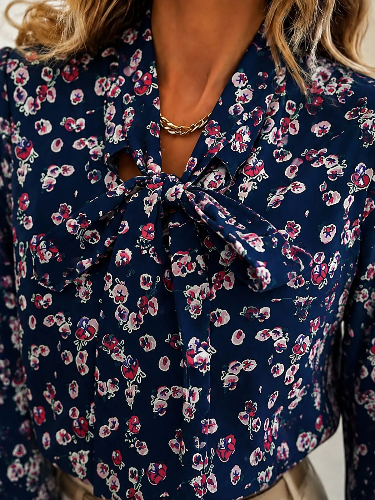 Navy printed blouse with bow tie at V-neck and long puff sleeves