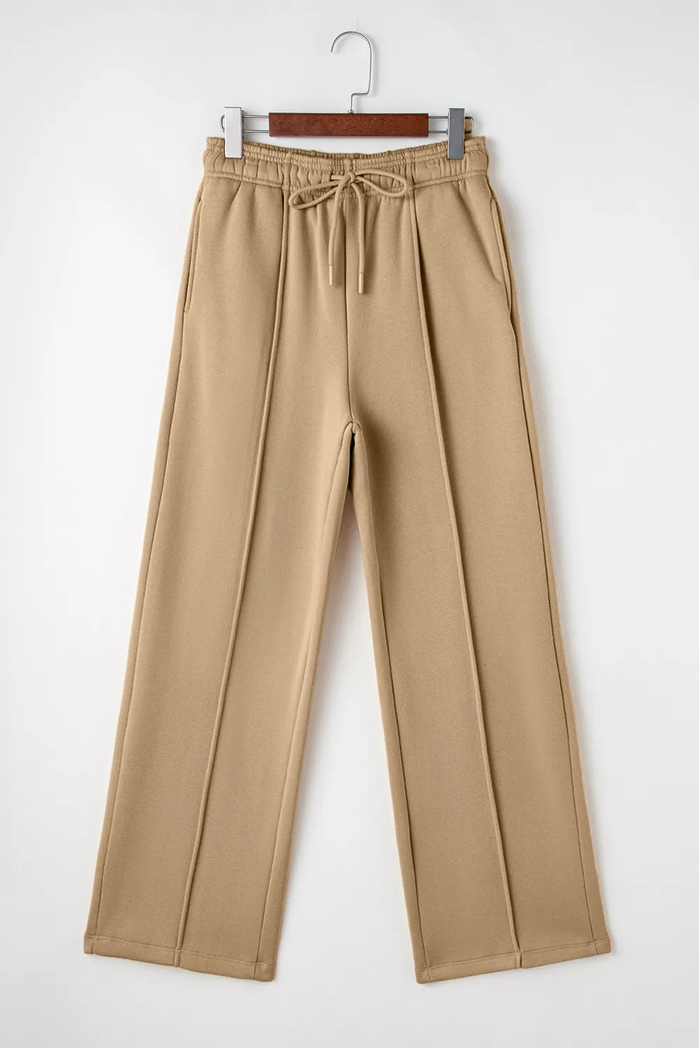 Tan wide-leg drawstring pants on hanger, front view with side pockets