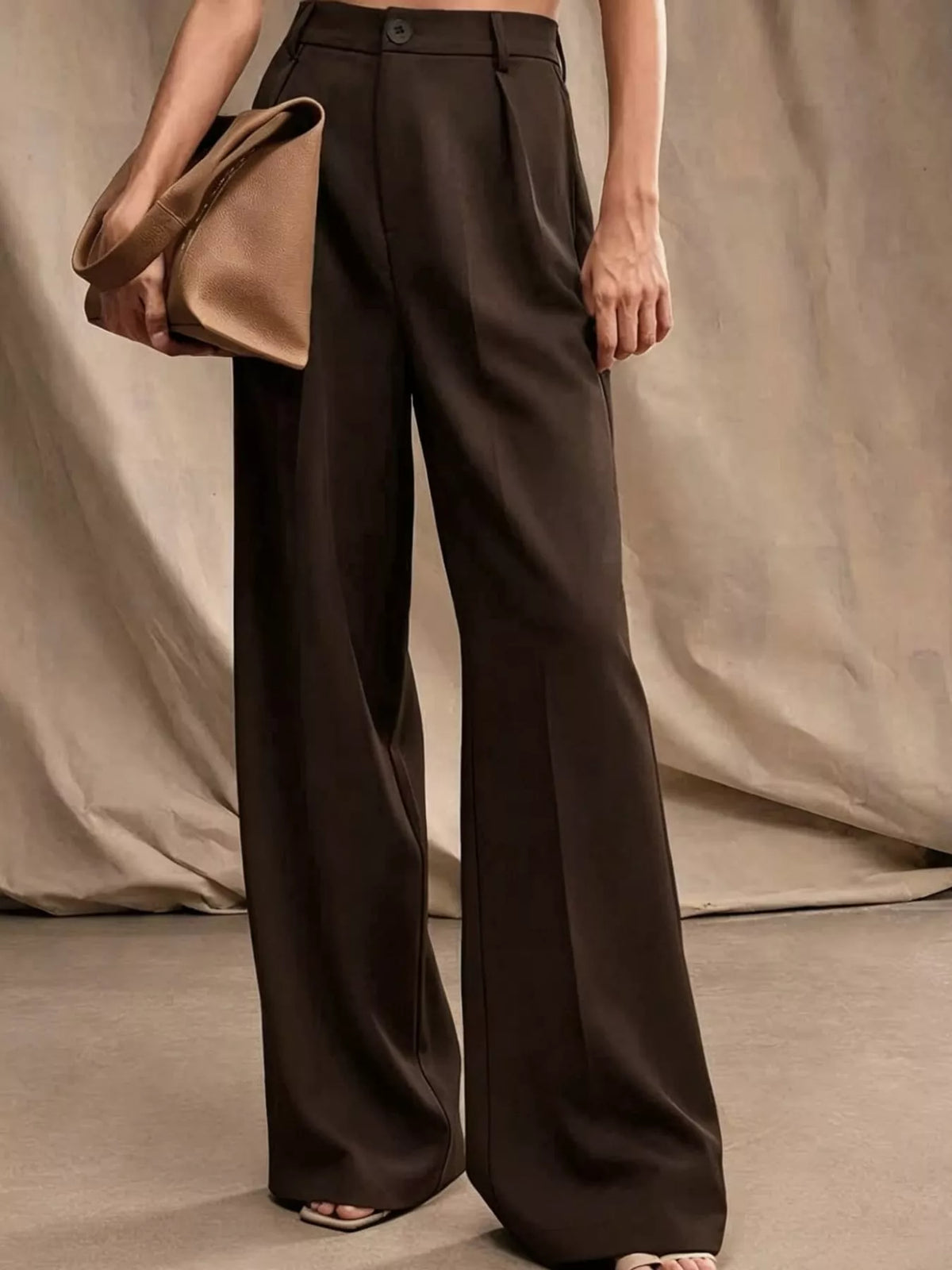 Dark brown high-waisted pleated wide-leg pants, side view, belt loops and pleats