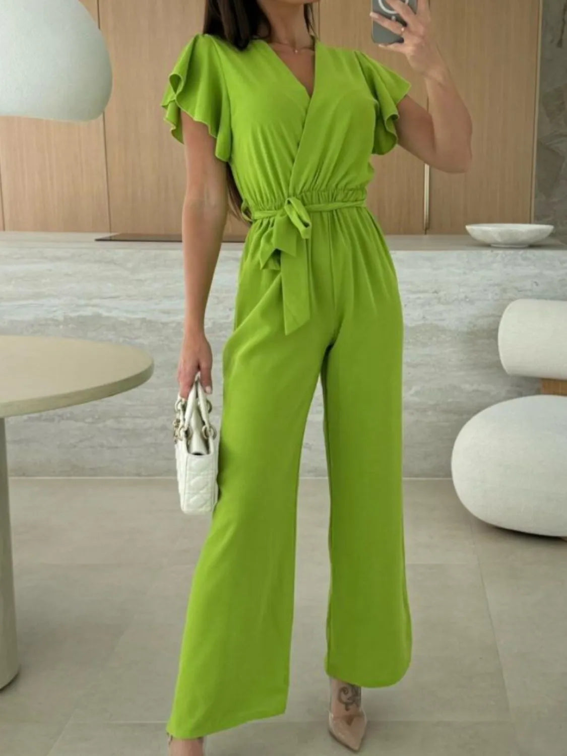 Lime green wide-leg jumpsuit with ruffled shoulders and tie waist