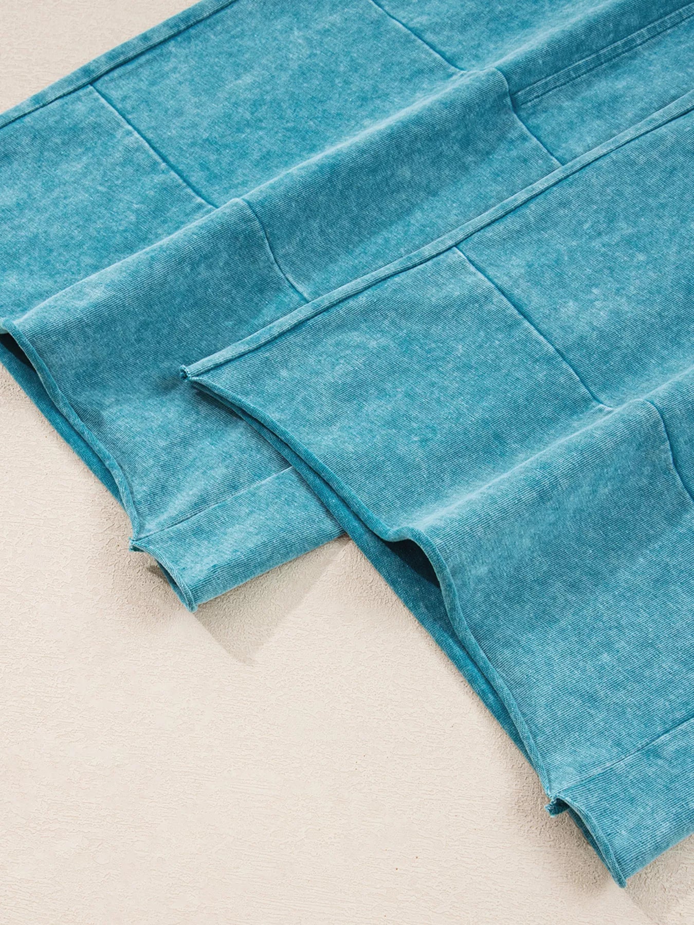 Teal mineral-wash pants with stitched seam panels and folded cuff hem