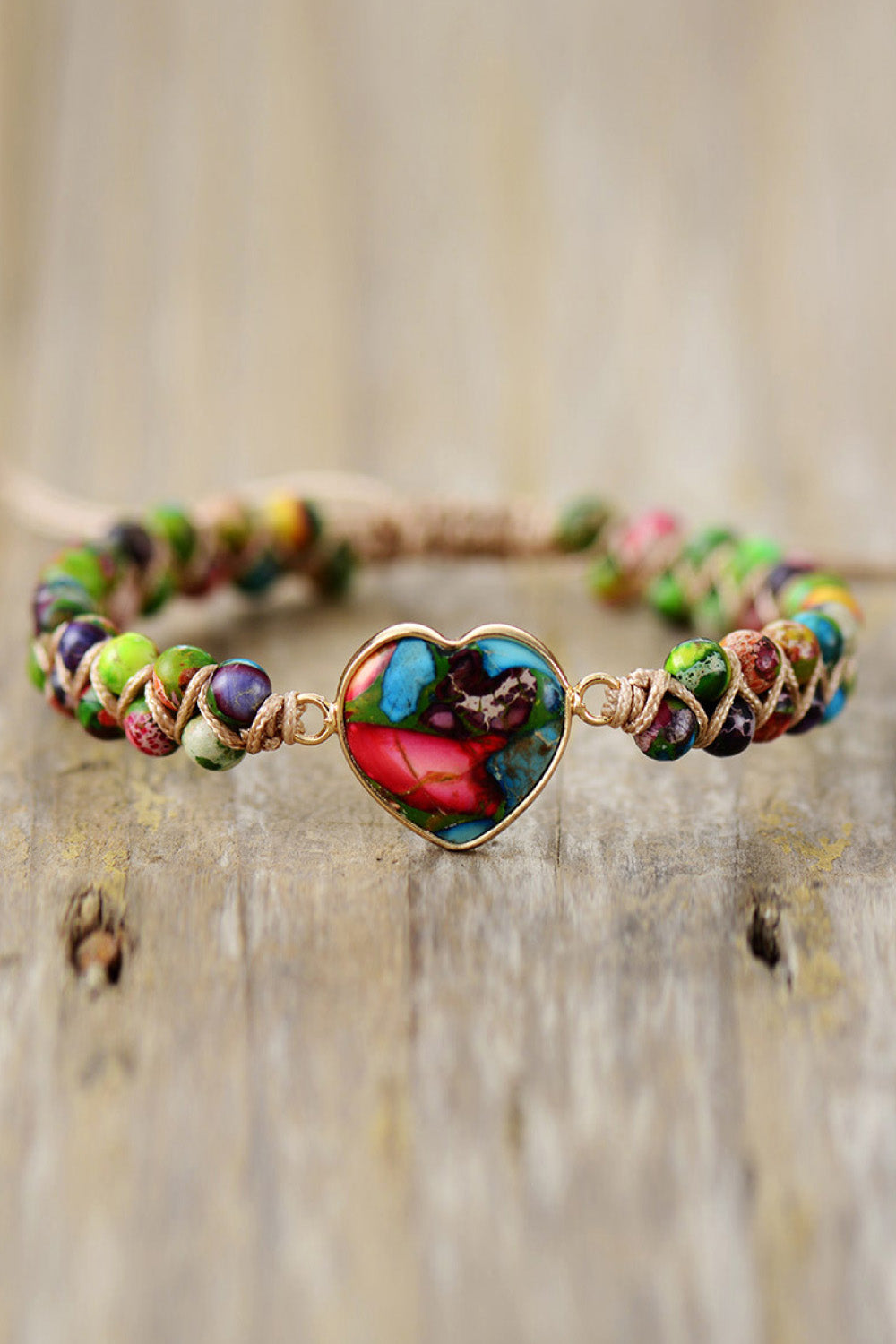 Multicolor braided bracelet with gold heart-shaped stone pendant with red and green tones