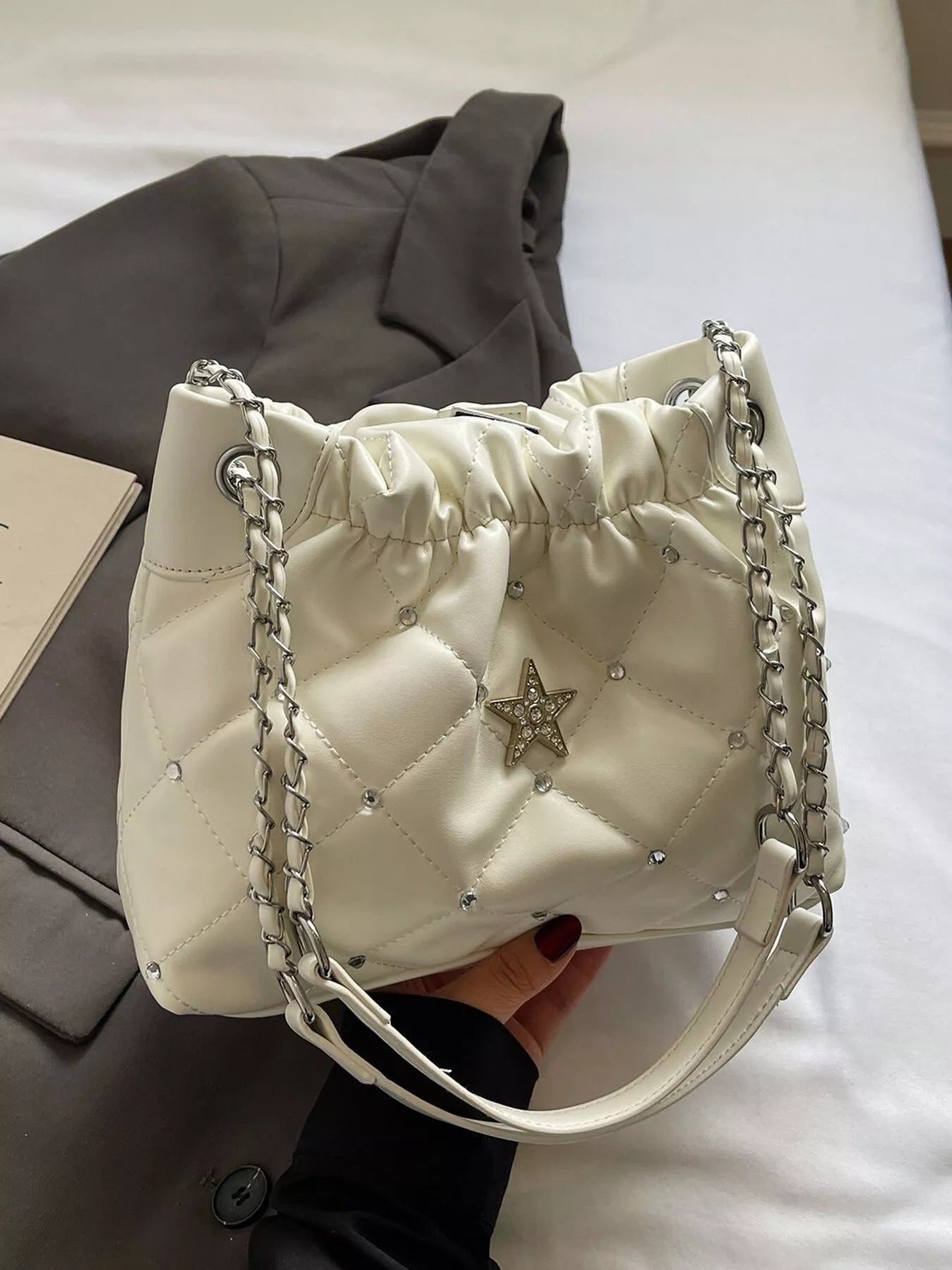 Quilted cream PU shoulder bag with rhinestone star decor and chain strap.