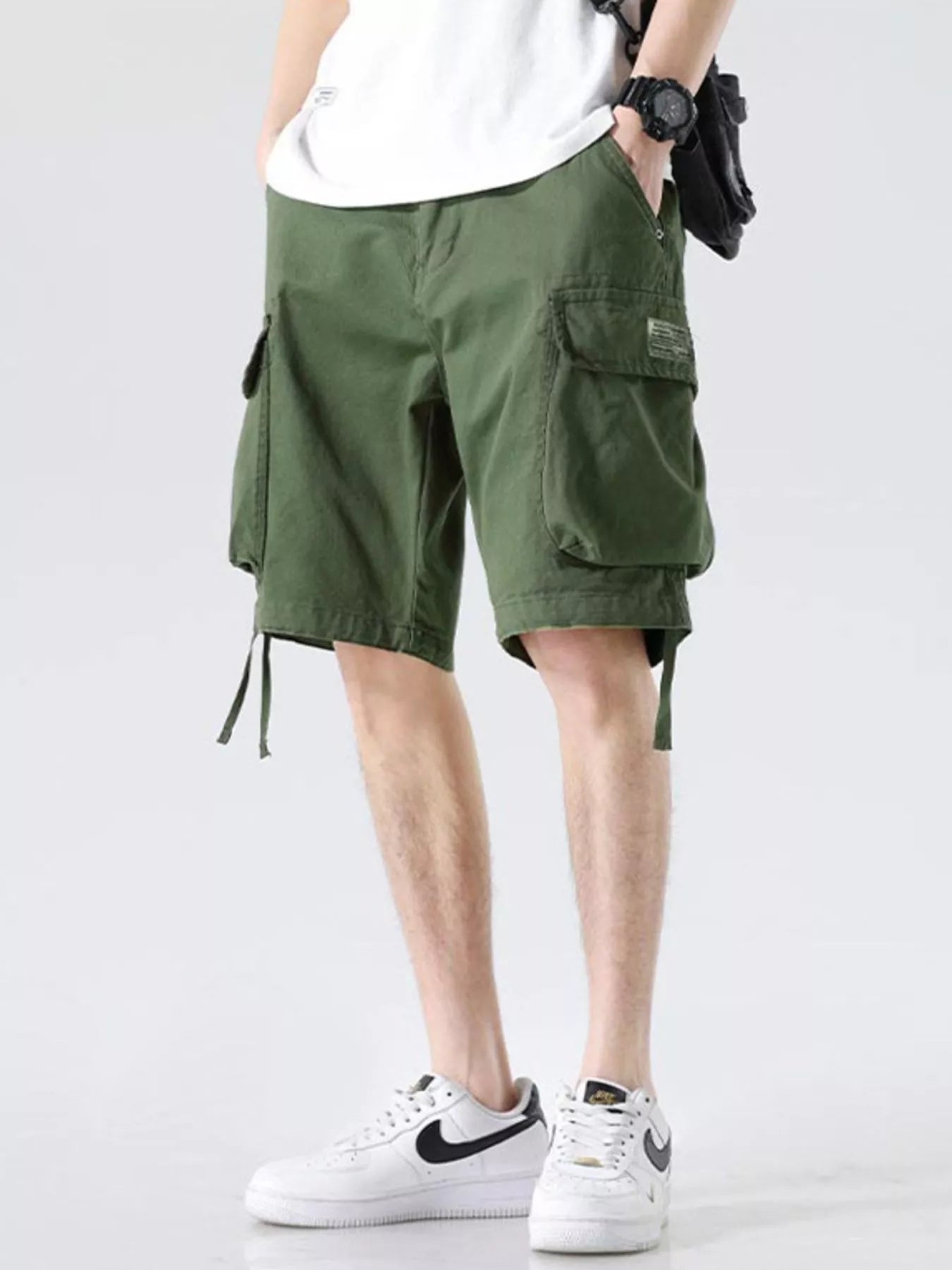 Military green cargo shorts with cargo pockets and drawstring hem ties, relaxed wide fit