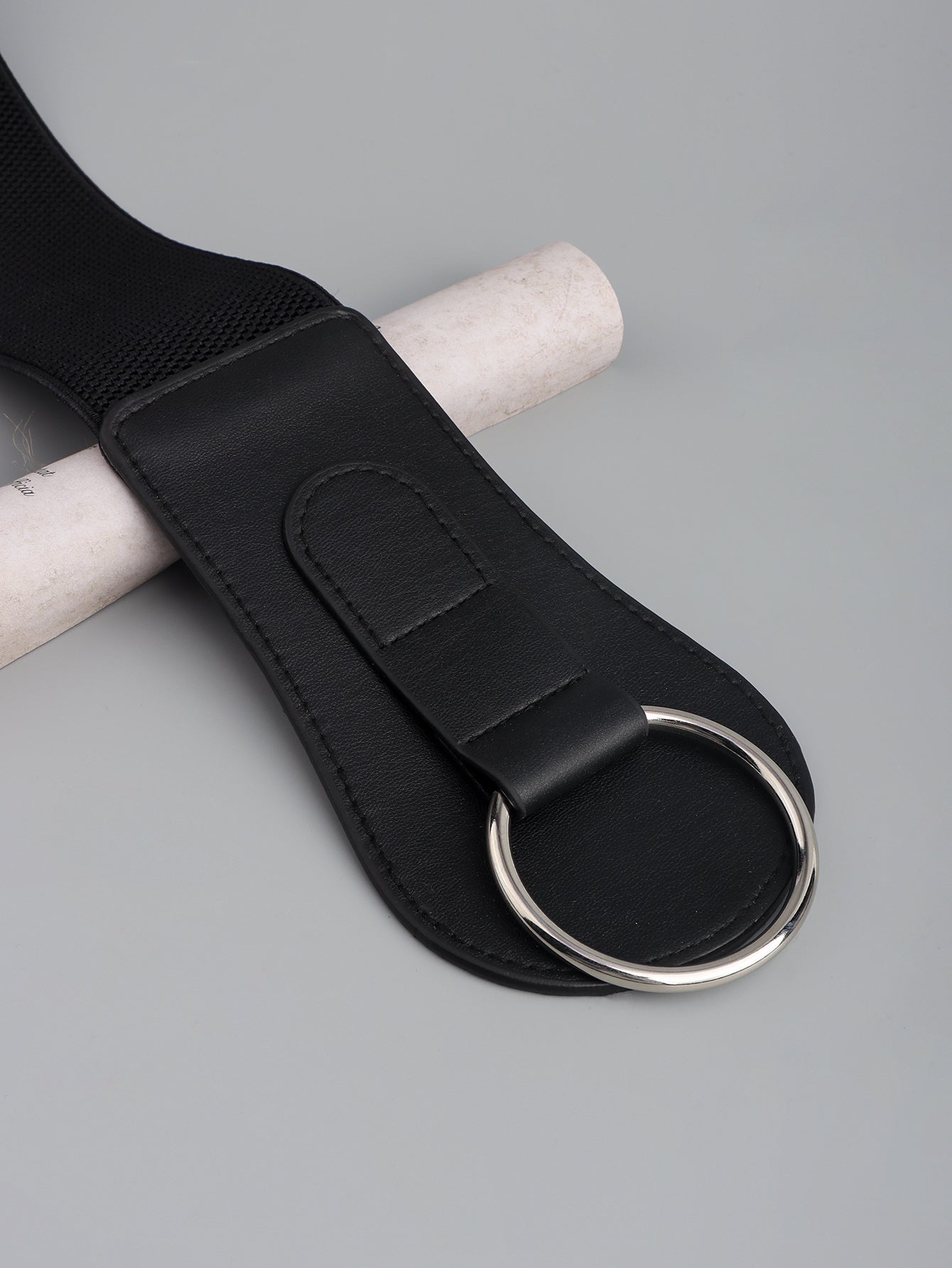 Black wide elastic belt close-up with silver O-ring and textured elastic back