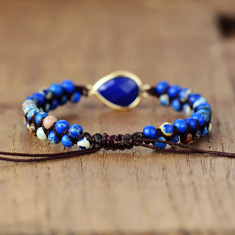 Blue beaded bracelet with large teardrop dark blue center stone and gold-tone trim