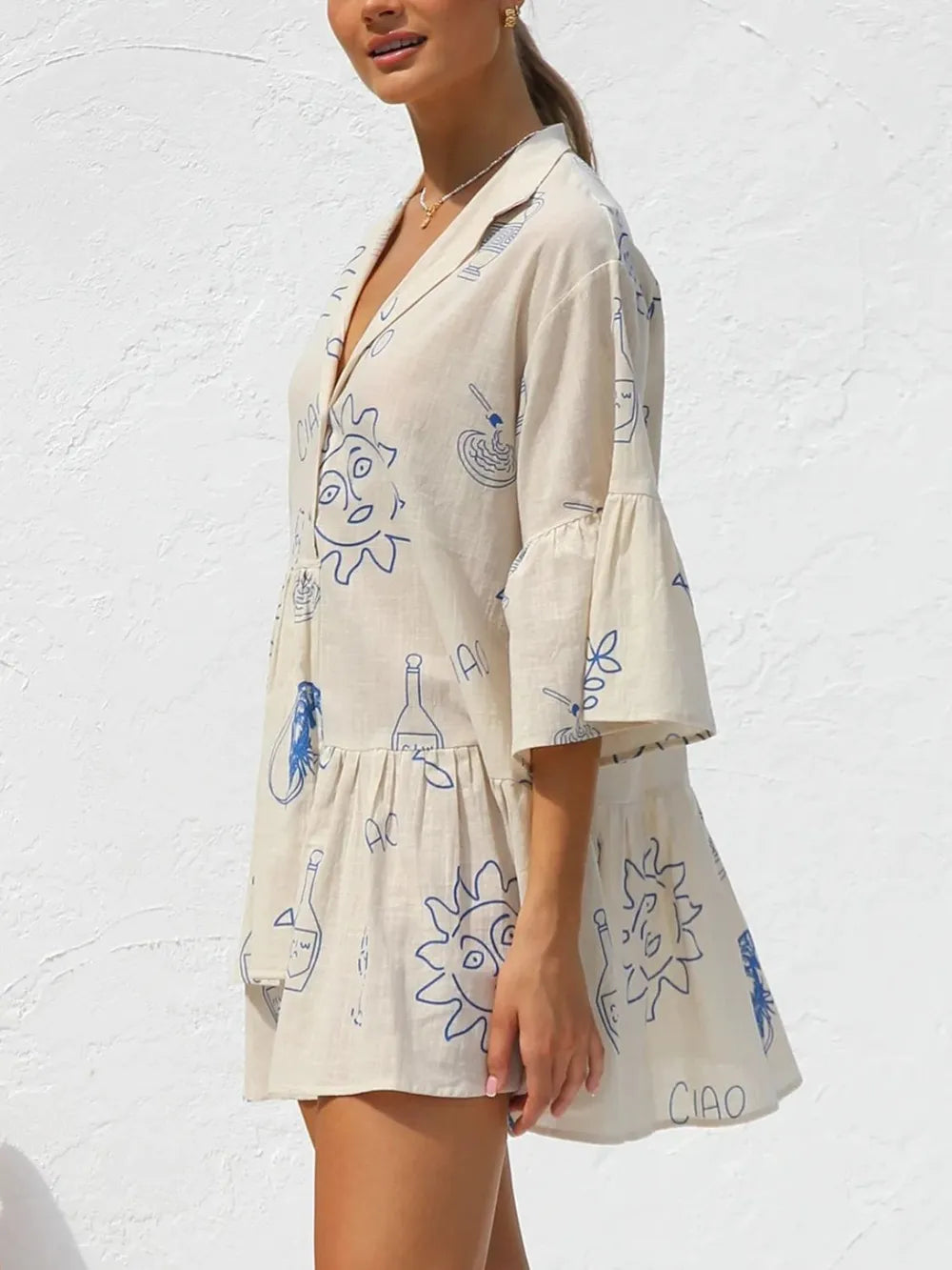 Cream printed mini dress with button-front V-neck, blue doodle motif, and flared hem