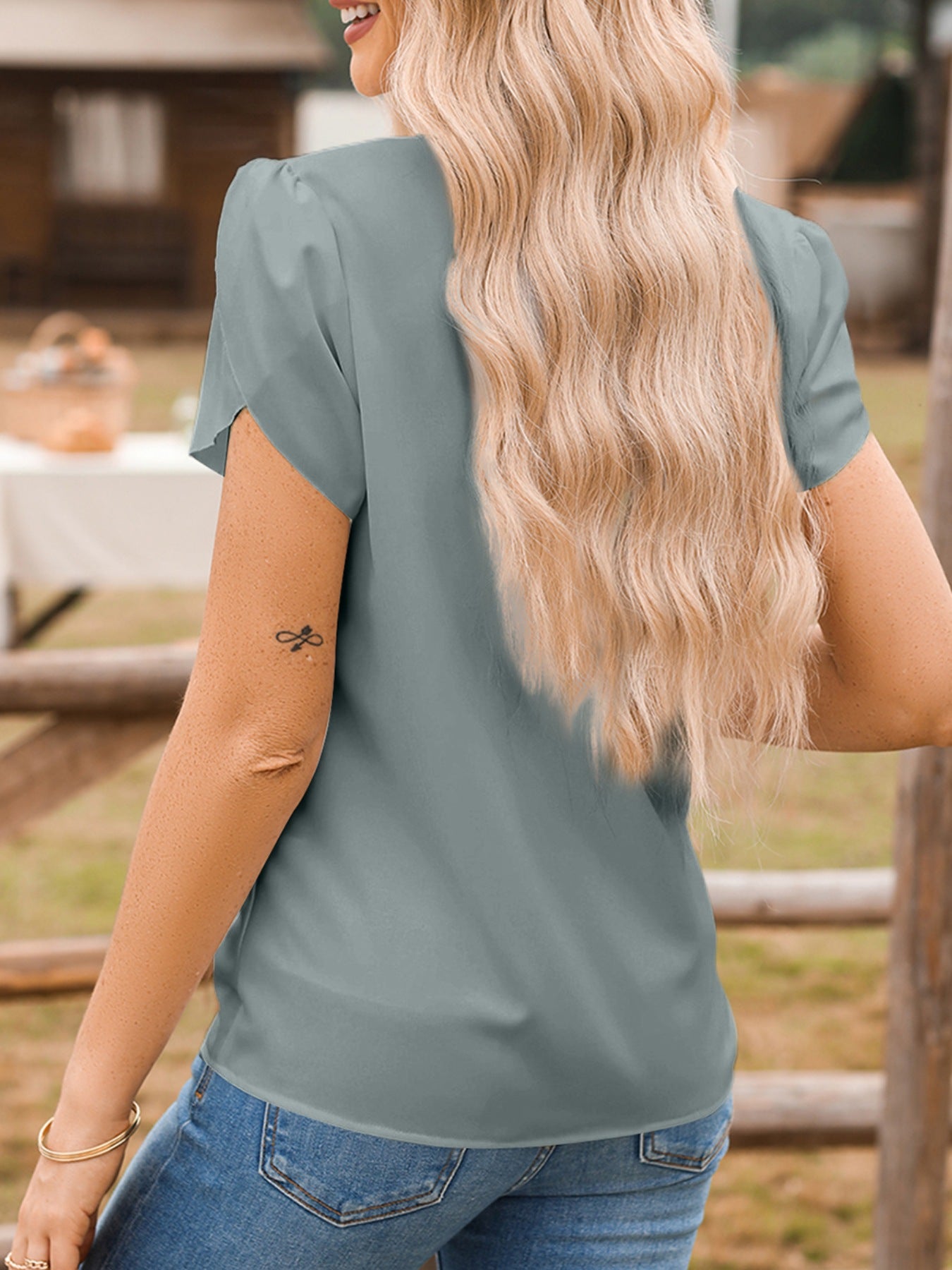 Notched Neckline Petal Sleeve Blouse in blue-gray, shown on model with jeans