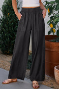 Black wide-leg pants with smocked high waist, frilled detail, side pockets