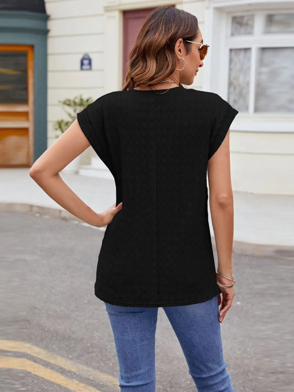Textured round neck cap-sleeve T-shirt in black, back view showing short cap sleeves.