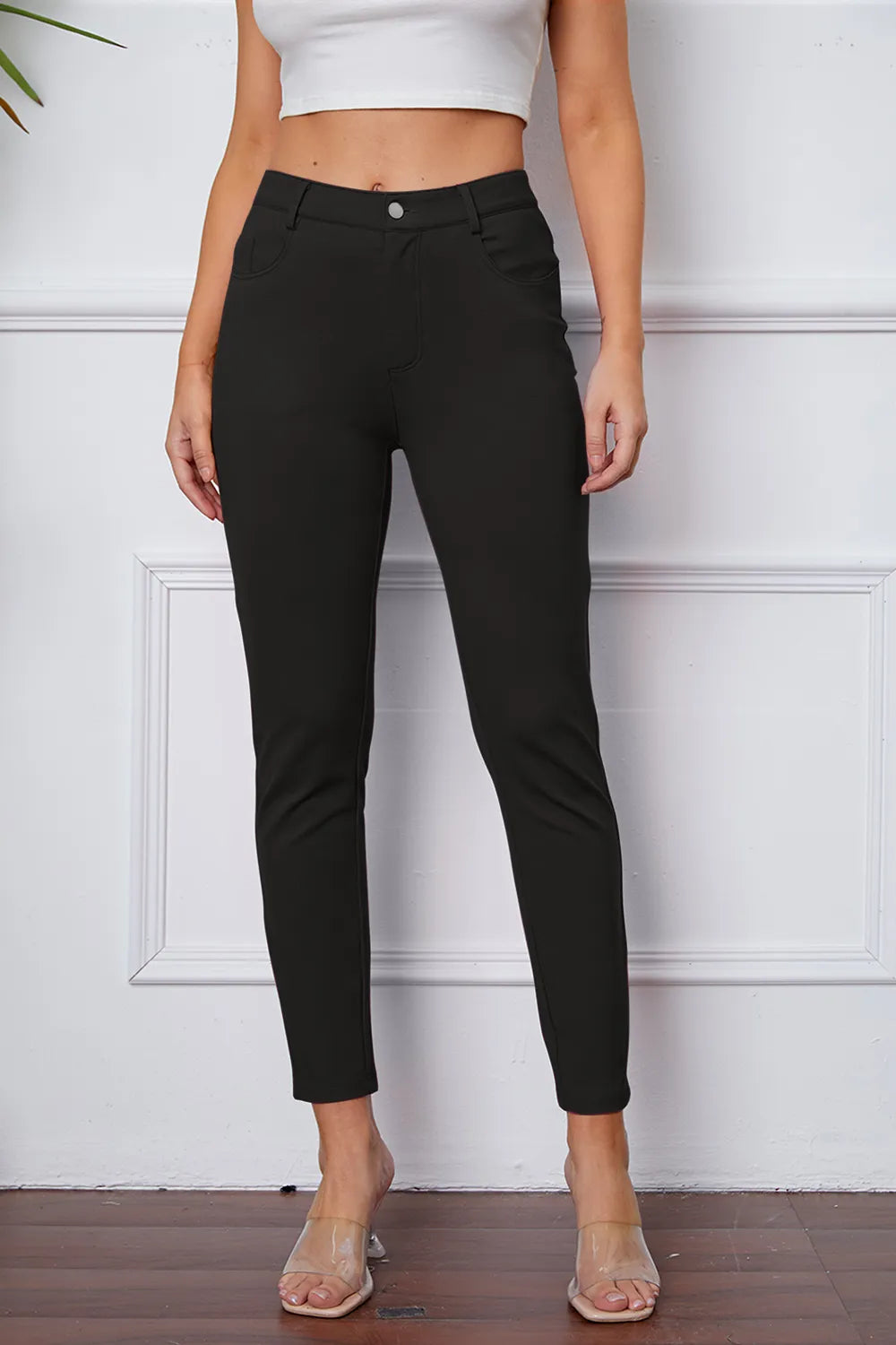 Stretchy black pants with button closure and slim ankle-length fit