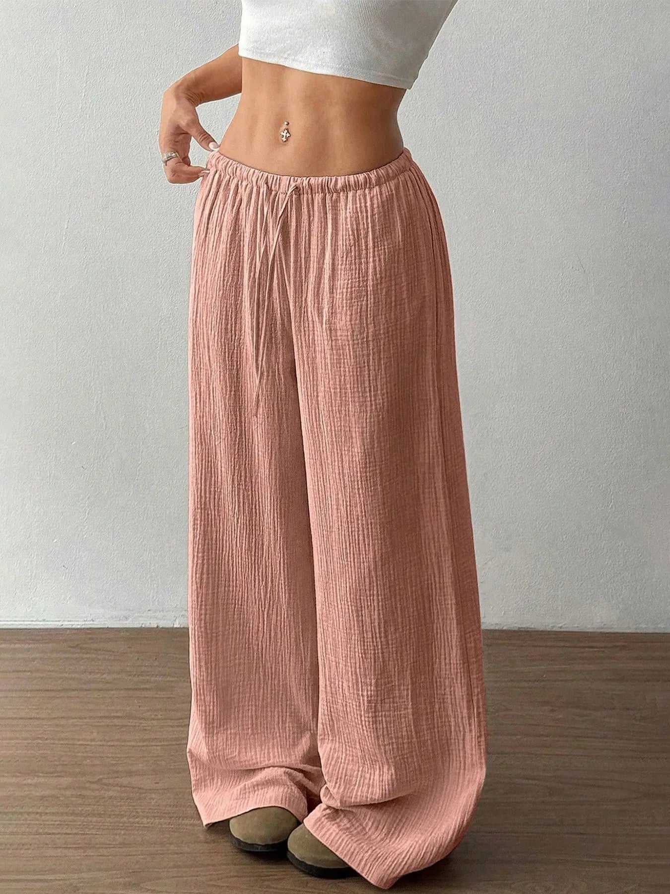 Dusty pink wide-leg drawstring pants with elastic waist and loose straight legs