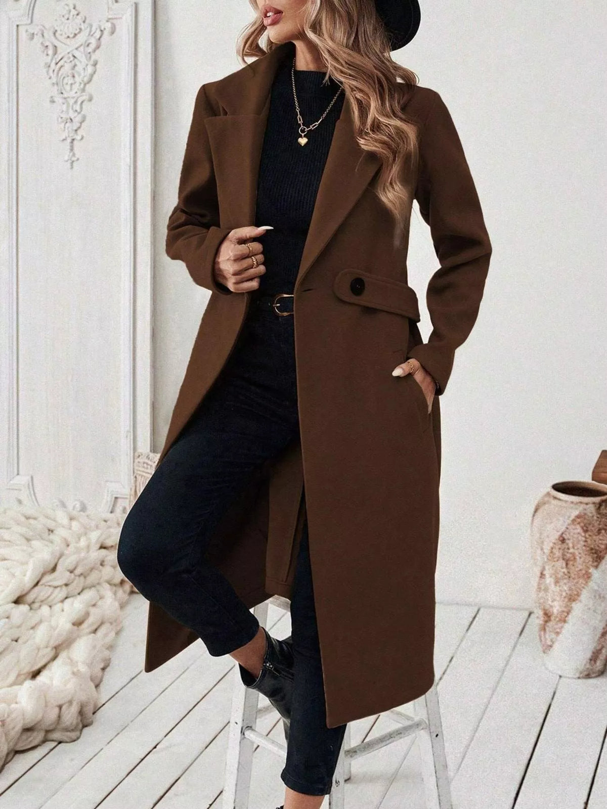 Longline single-button coat with notch lapels, chest flap pockets, and dark brown fabric