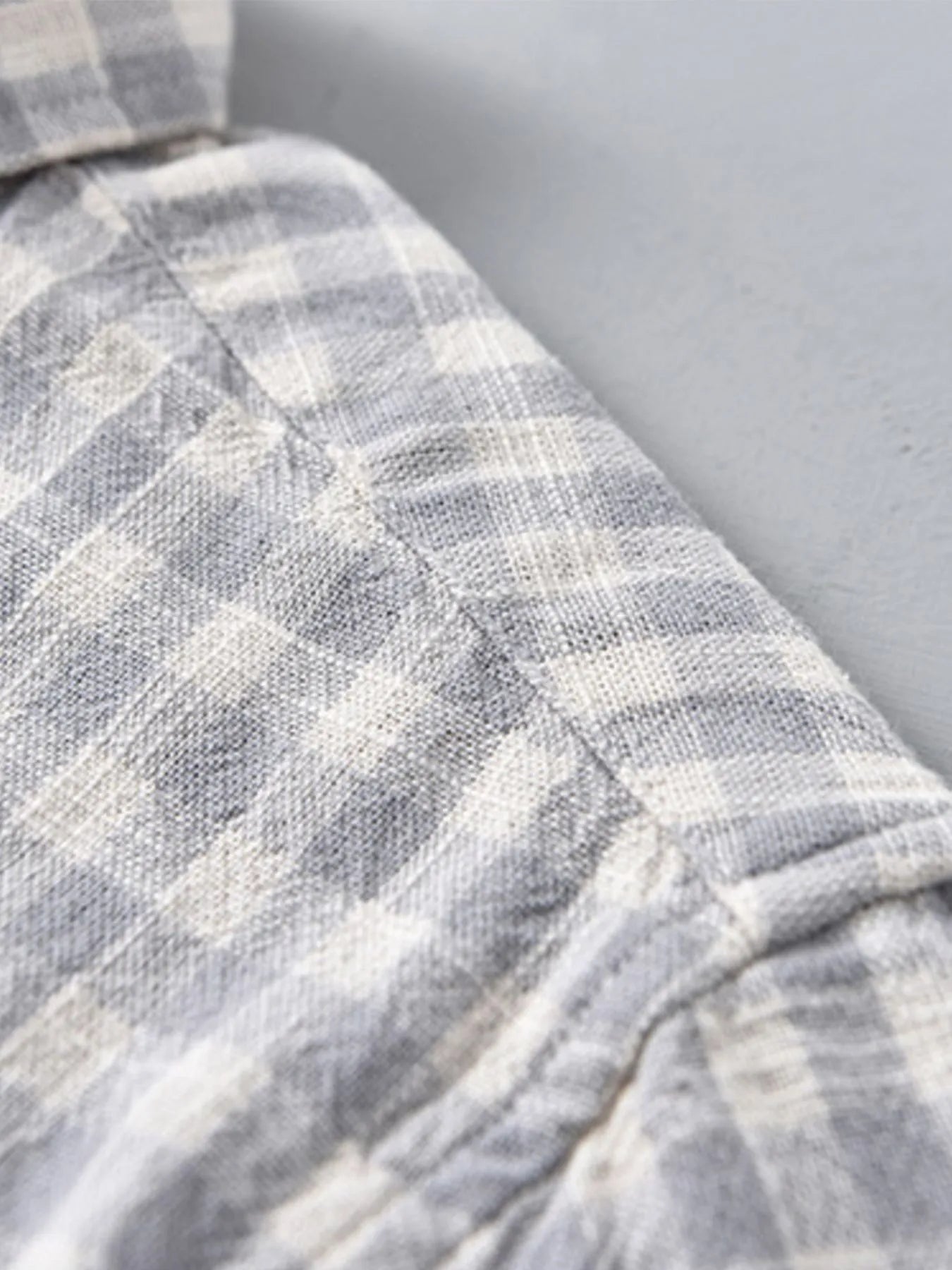 Light gray plaid button-up long-sleeve shirt with visible sleeve cuff