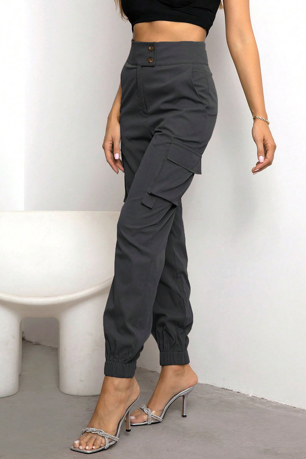 High-waist black cargo pants with button front, cargo pockets, ankle cuffs