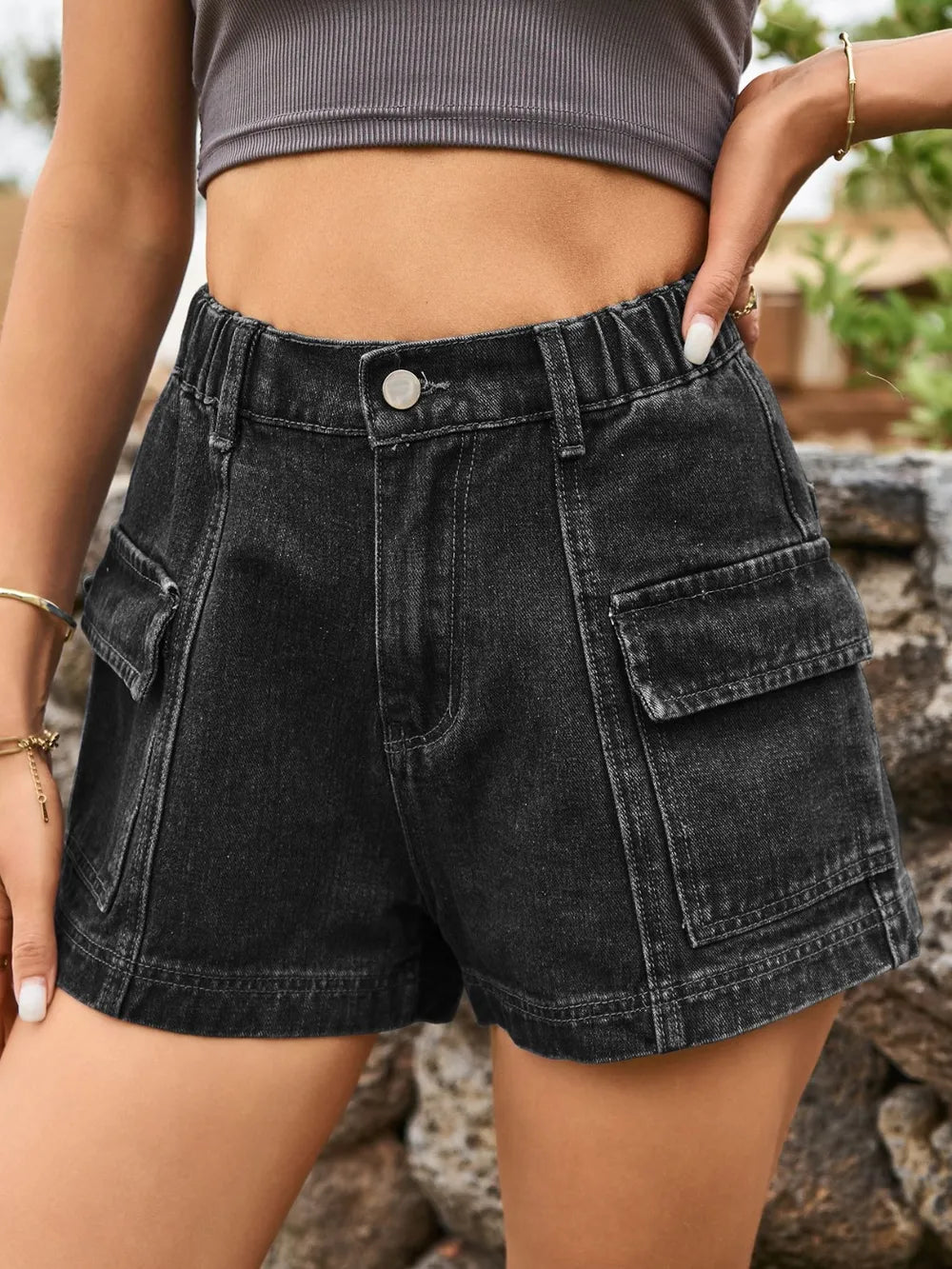 Black high-waist denim shorts with front button, belt loops, and patch cargo pockets