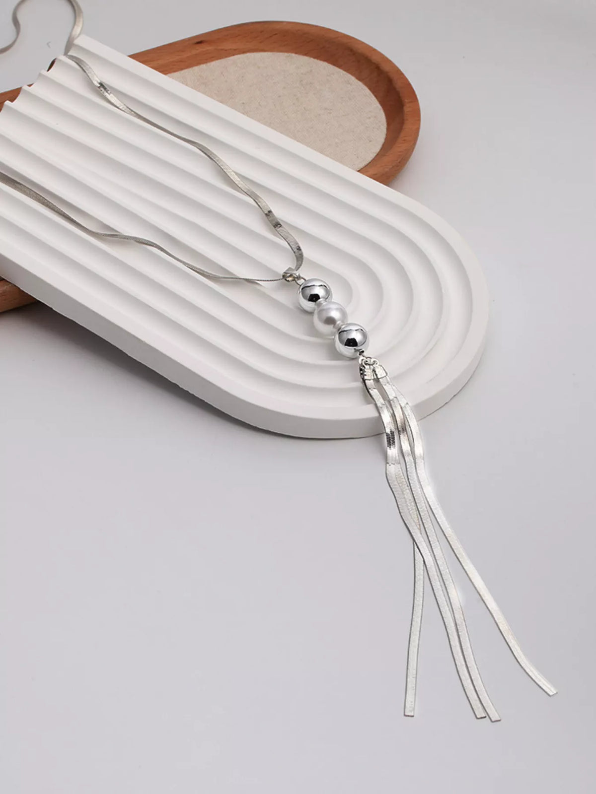 Silver beaded tassel necklace with spherical beads and long fringe threads